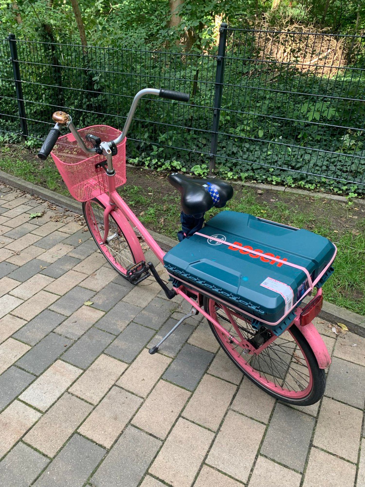 Mein Fahrrad: Ein pinkes Jopo-Fahrrad von Helkama mit pinken Reifen, einem pinken Korb und einer bronzefarbenen Fahrradklingel. Der jopo-Schriftzug ist weiß.