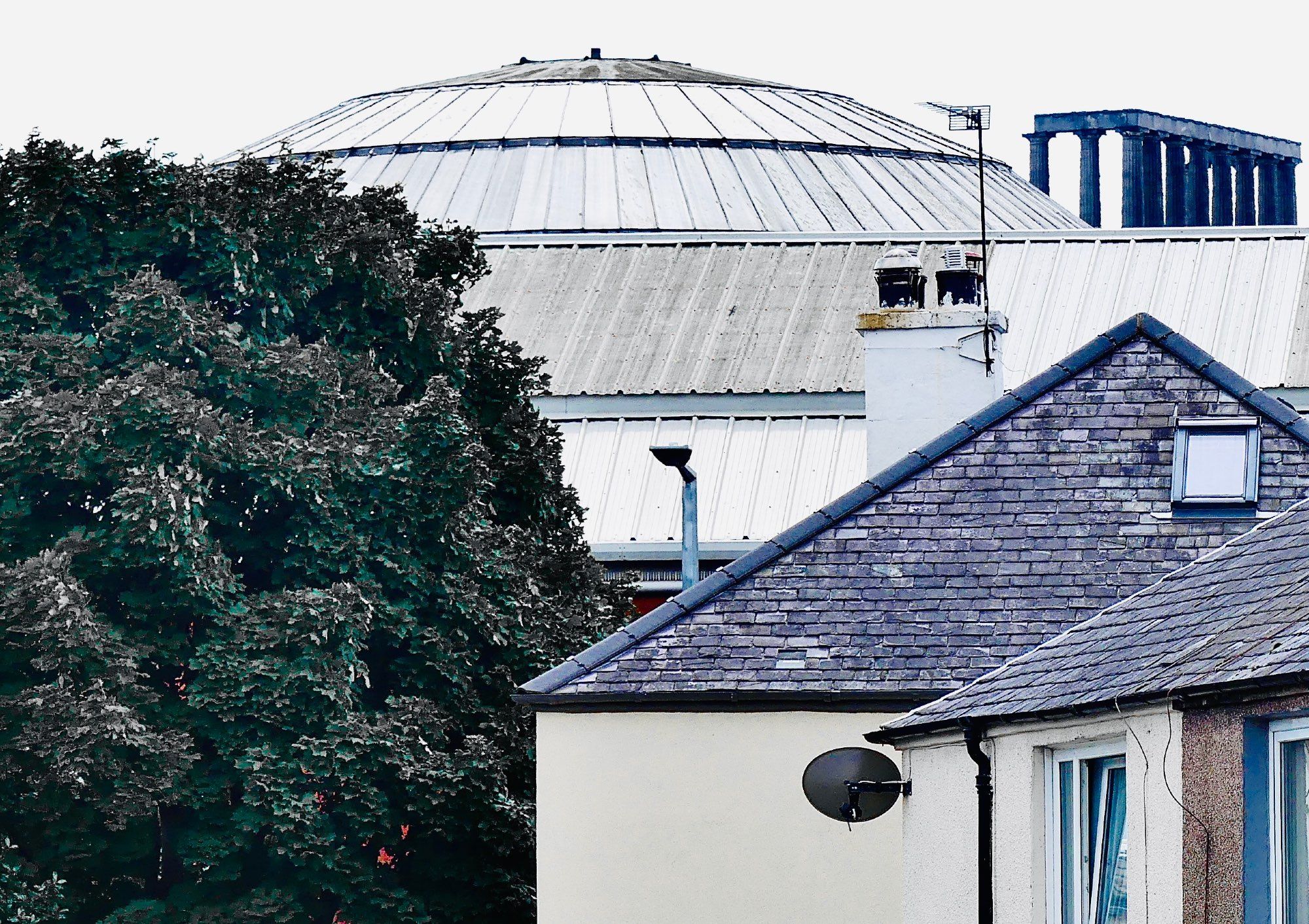 Depot roof and glass dome of the Industrial Hall with National Monument in the background and 1930s Miller Homes in the foreground.