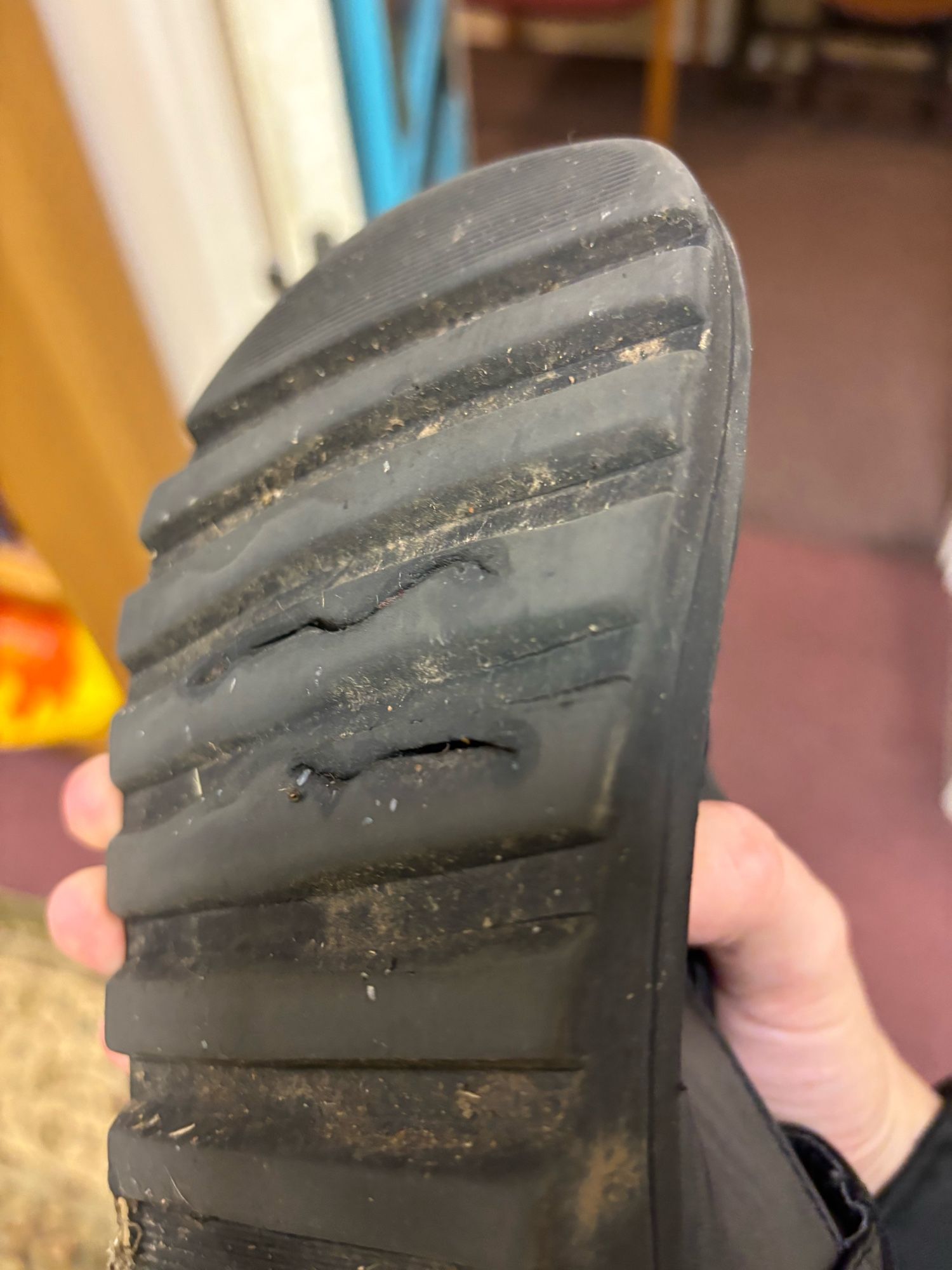 The sole of a shoe which has two visible cracks in it.