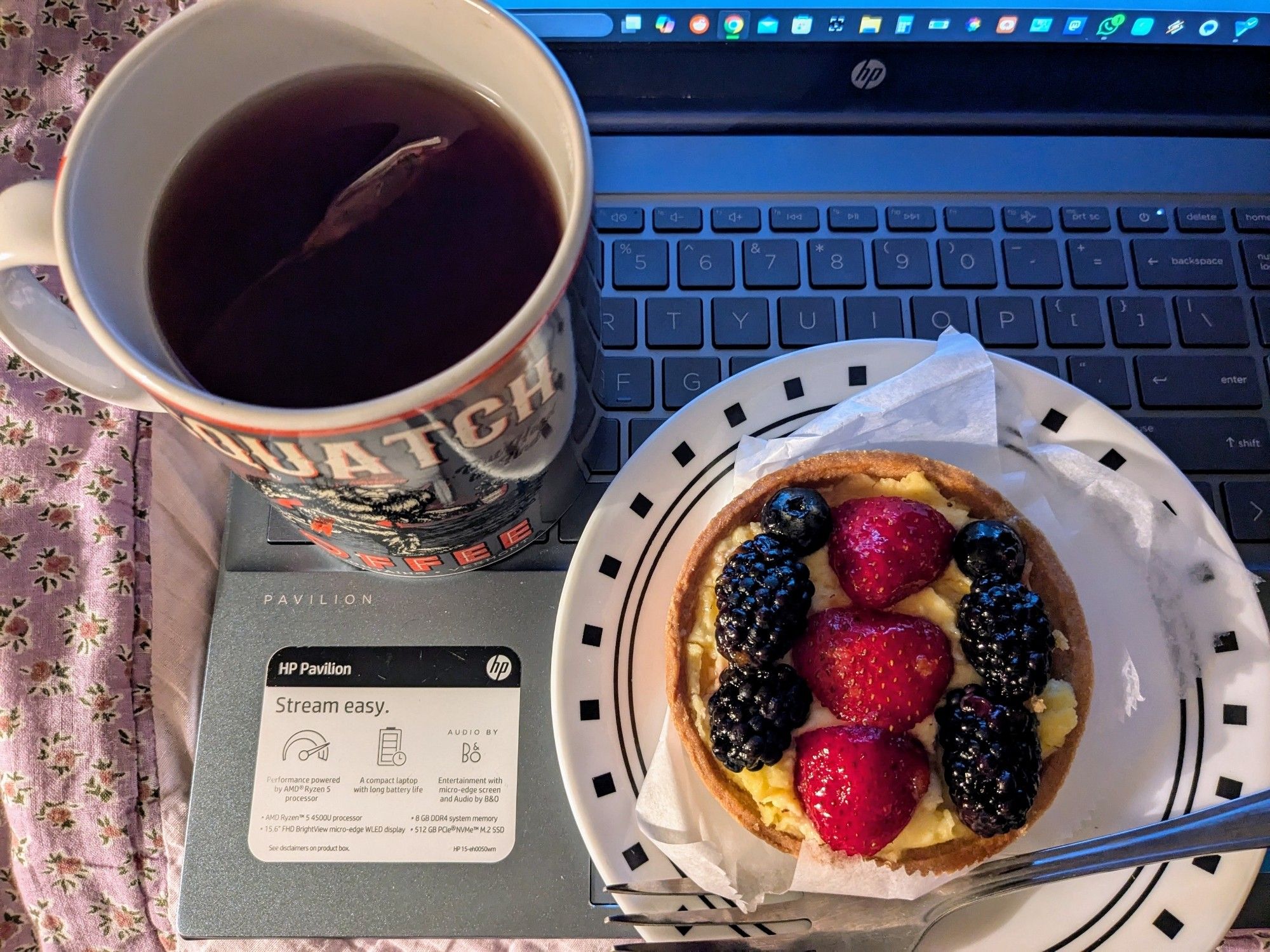 A cup of tea and a raspberry and strawberry dessert on a plate. Yes, I'm an idiot for placing the tea on the laptop.