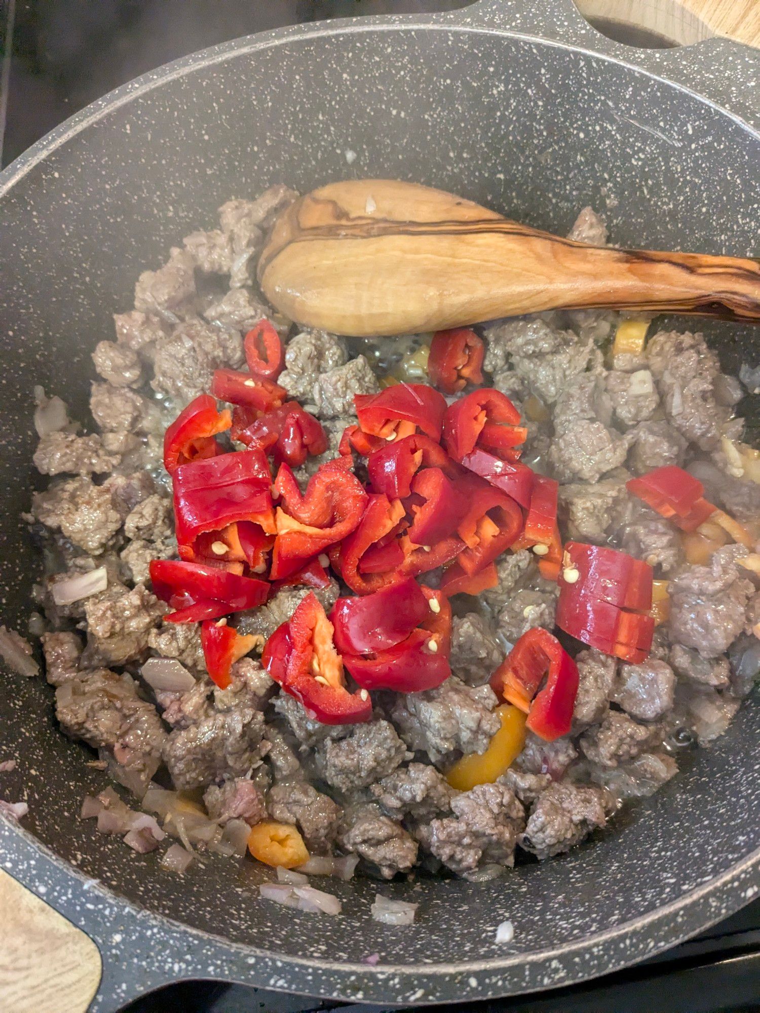 Beef onions, garlic, peppers, and spices frying in a pan