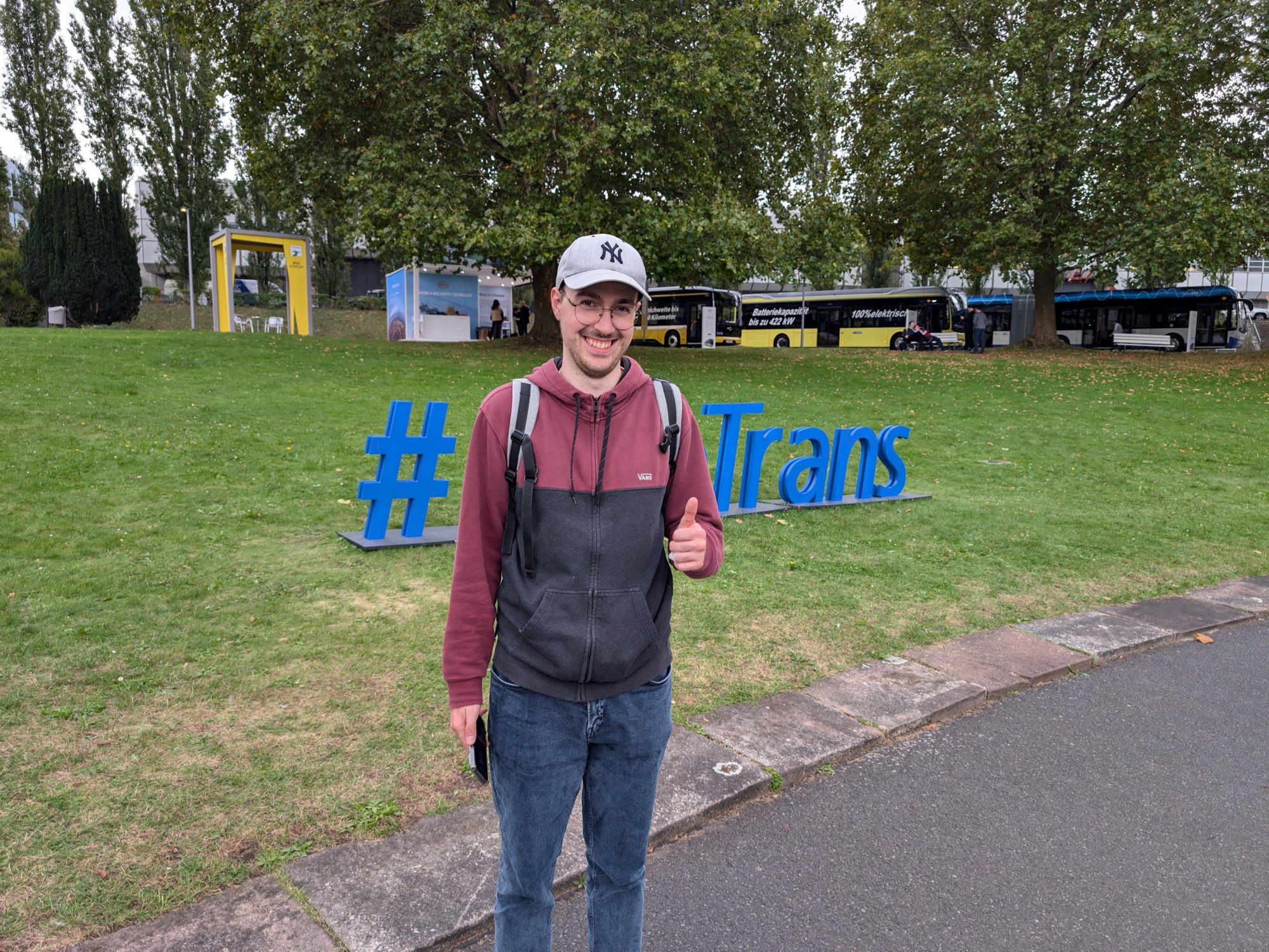 Foto von mir vor dem “#InnoTrans”-Schild, wie ich den Daumen hebe. Dabei stehe ich genau vor dem Textabschnitt “Inno”, sodass nur # Trans zu sehen ist.