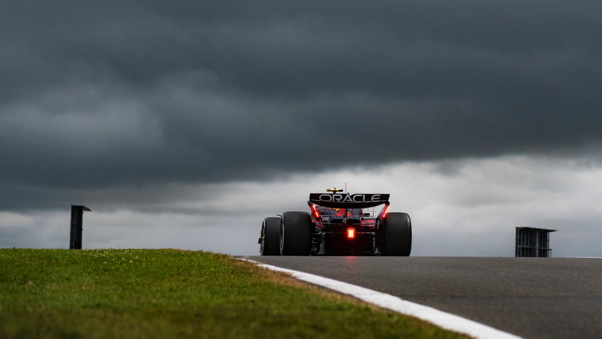 Picture from behind showing a RB20 at the top of the hill, dark clouds in the background.