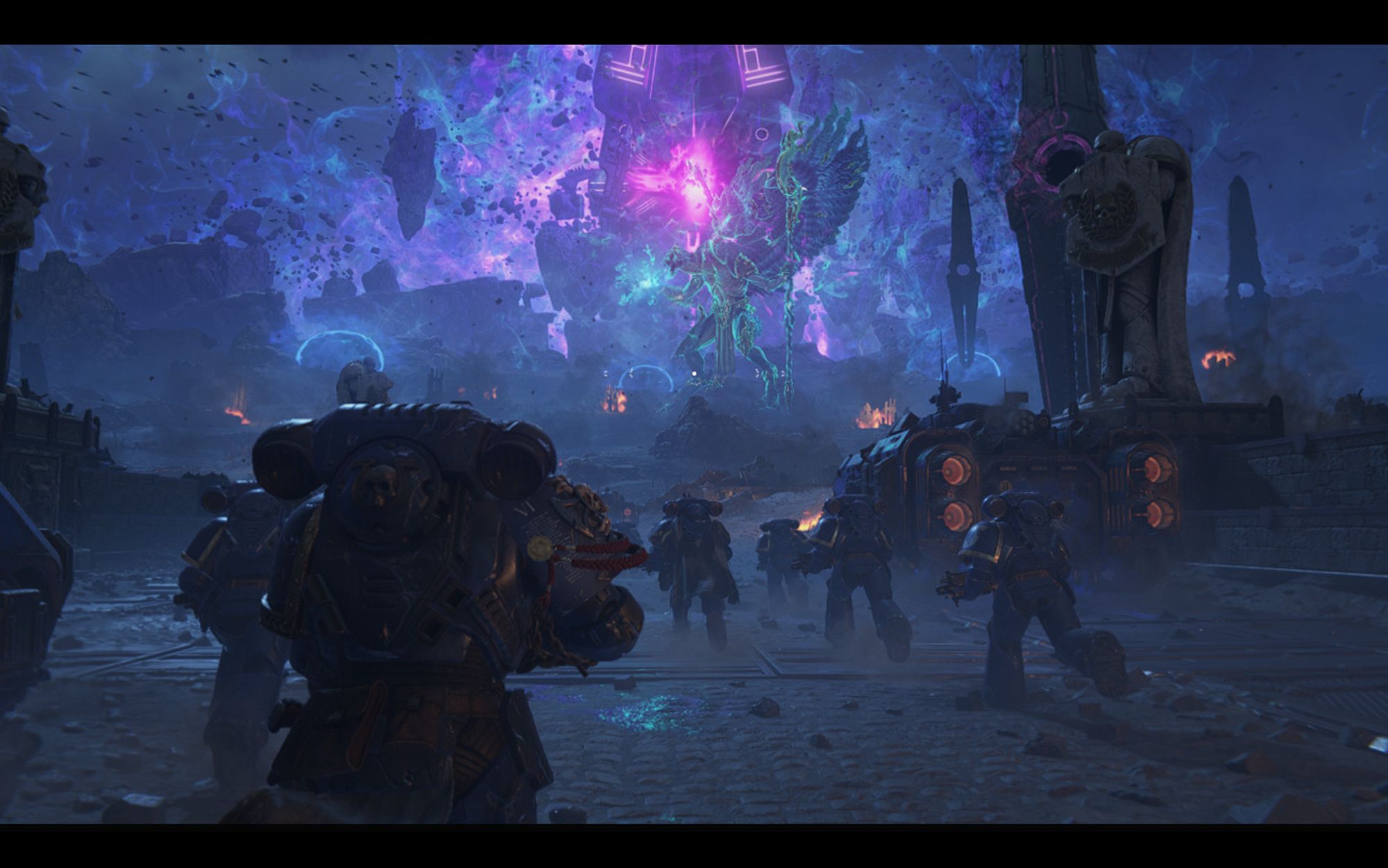 The Ultramarines are about to get down with the Thousand Sons- a digitally rendered battle scene from the Warhammer 40,000 universe. In the center of the screenshot is a purple warp rift and a massive demon with two buzzard heads, huge wings, and a humanoid form. It's known as The Changer of Ways, a big bad of the Chaos God T'zneentch (I think that's how you sp). Several Space Marines of the Ultramarines chapter in their dark blue battle plate rush towards the demon along with several grav tanks and Marneus Calgar himself, the Chapter Master