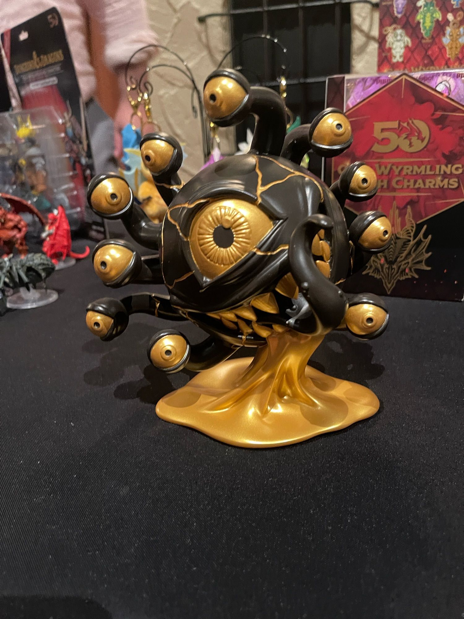 A gold and black statue that’s Wizkids upcoming Kidrobot beholder collaboration statue