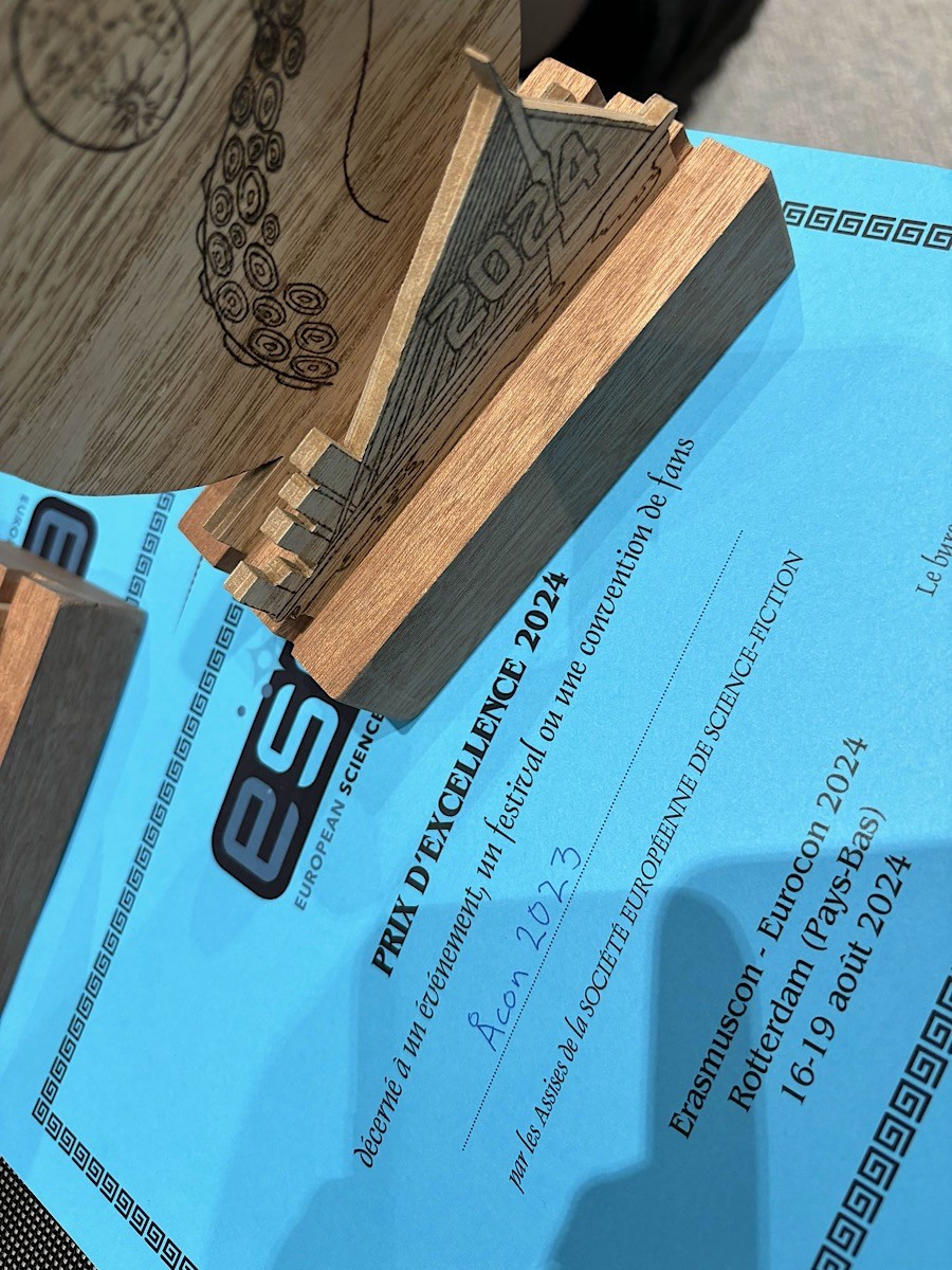 Wooden award trophy and a blue certificate of excellence for 2024 from the European Science Fiction Society.