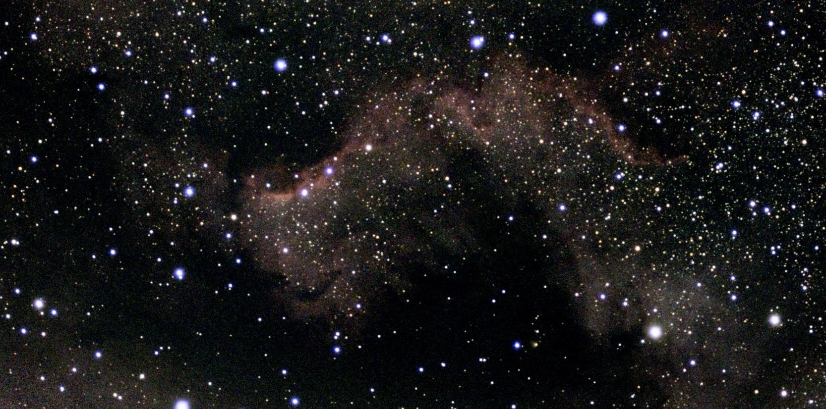 Background of stars with red clouds, showing the North American Nebula