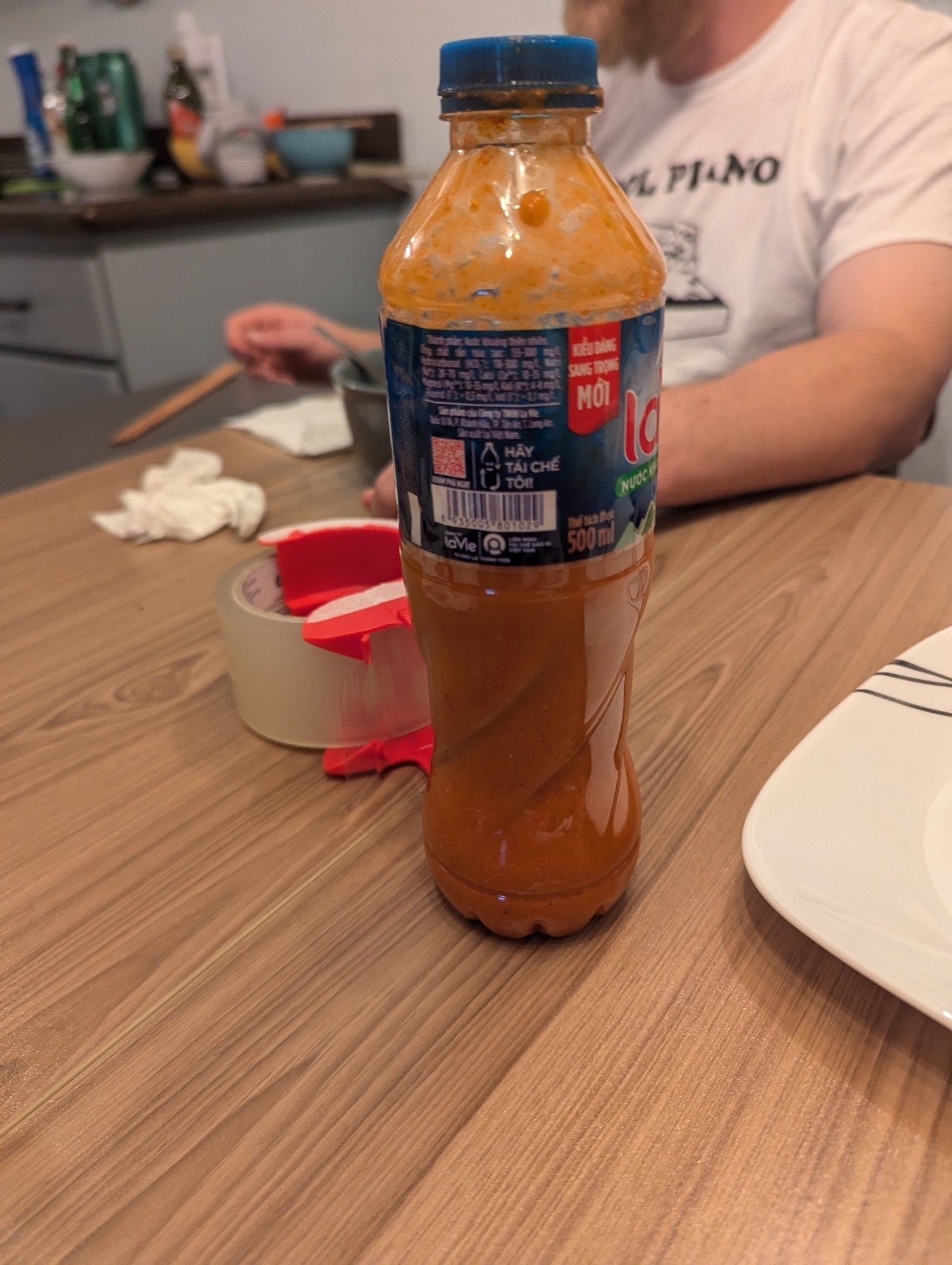 A water bottle filled with a vibrant orange sauce 