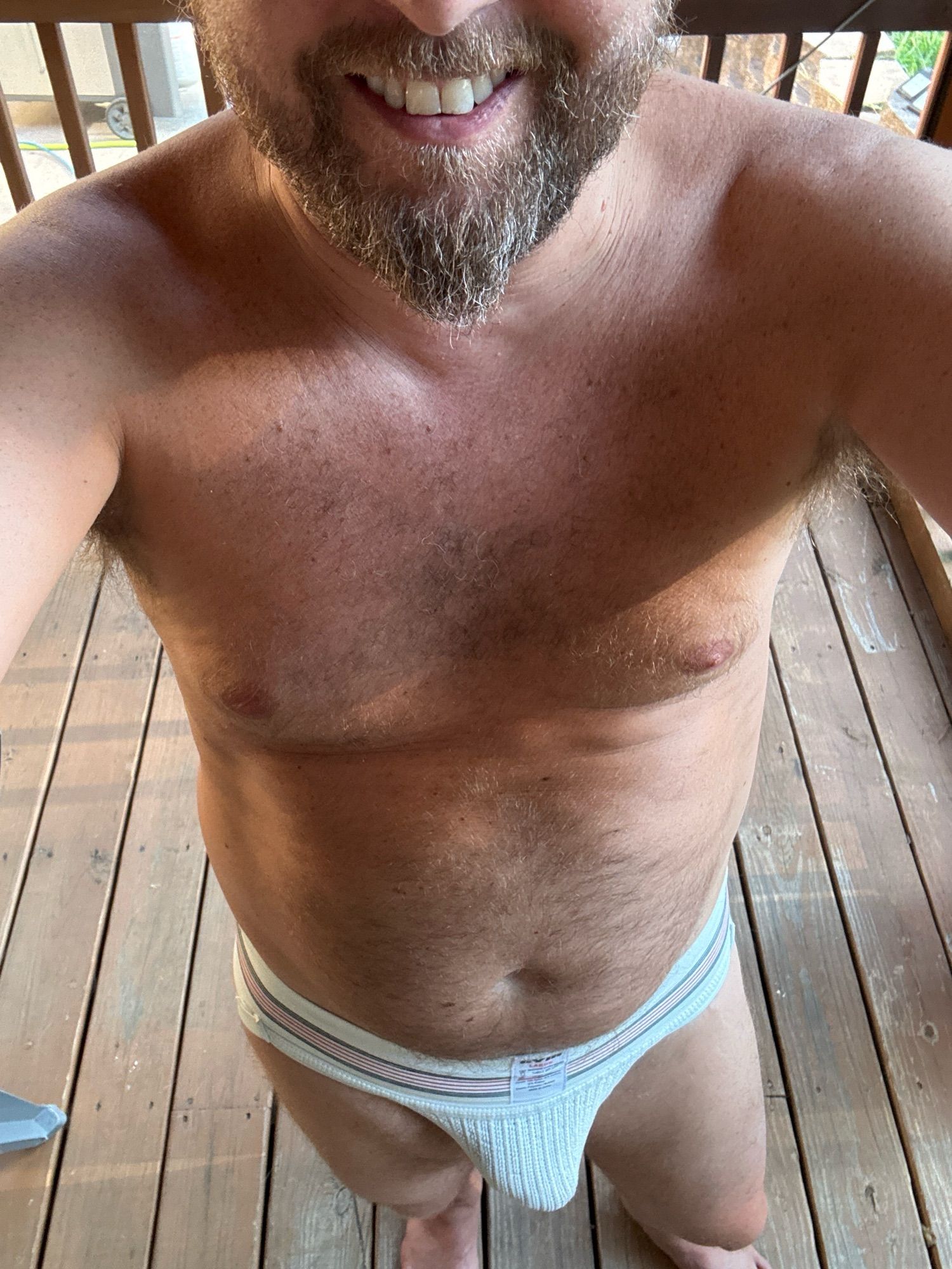 Man on back porch wearing just a jockstrap his husband picked up from a hookup