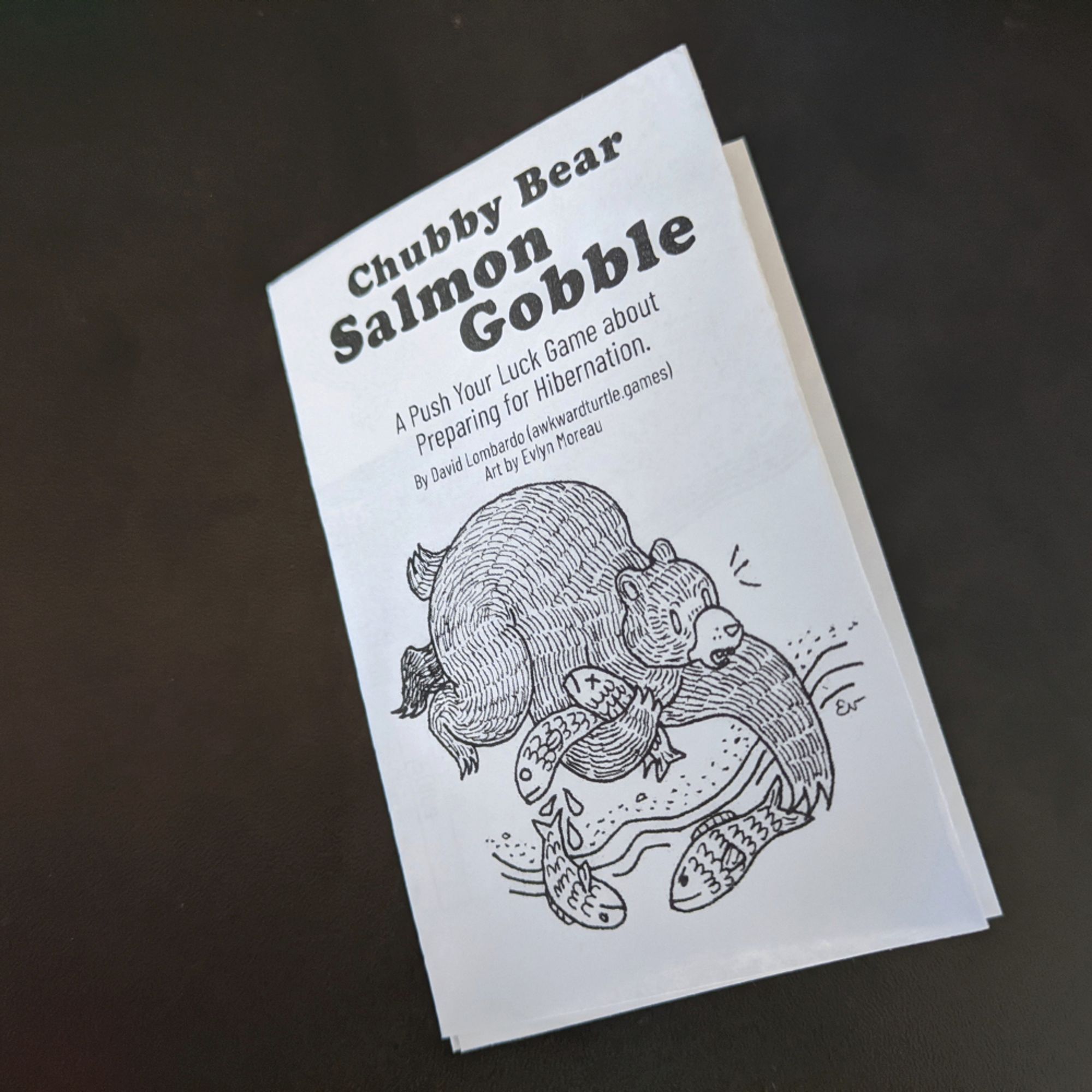 A small zine made by folding a single sheet of paper.

The cover of Chubby Bear Salmon Gobble shows a delightful drawing of a bear desperately trying to catch salmon from a river, while the salmon it's already caught wriggle out of its grasp.