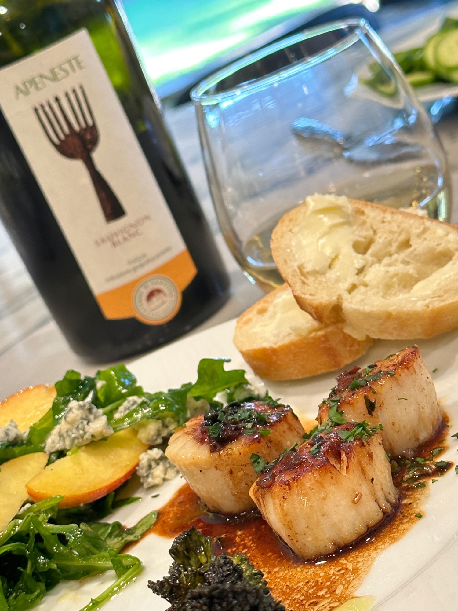 A meal of scallops wine nectarine salad and broccolini 