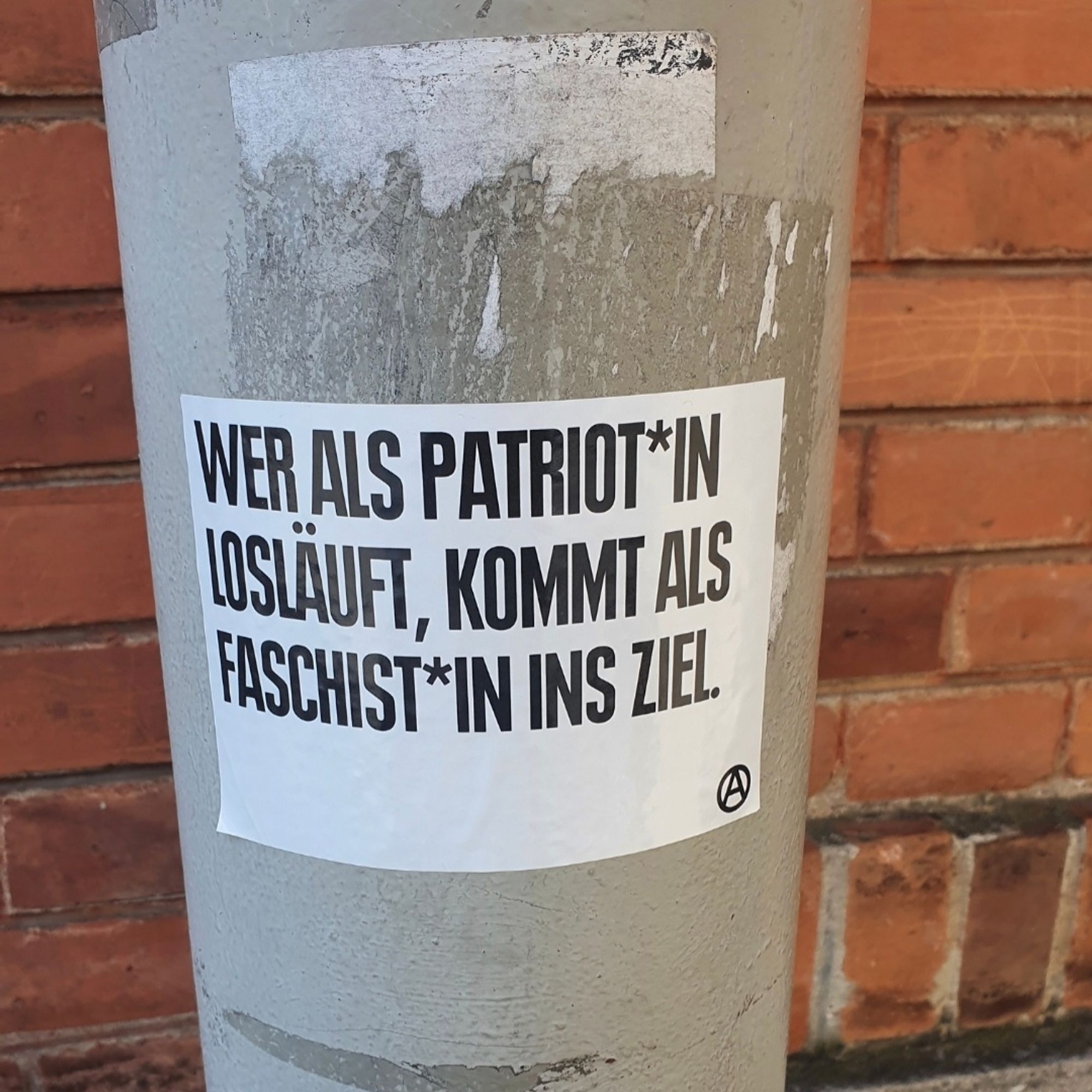 sticker mit aufschrift: " Wer als Patriot *in losläuft, kommt als Faschist*in ins Ziel