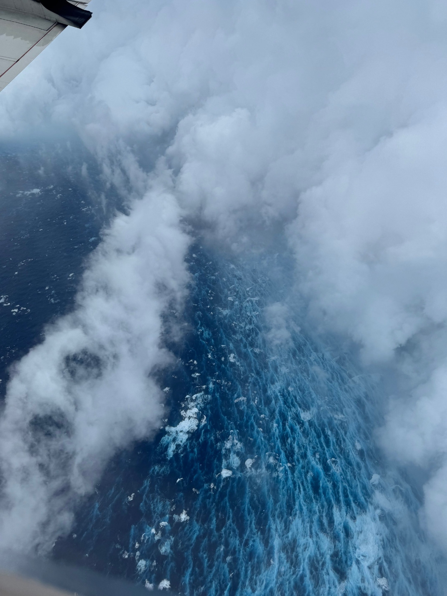 Photo from the perspective of the NOAA Hurricane Hunter aircraft in the eye of Hurricane Erin. A blue ocean can be seen along with the clouds marking the edge of the hurricane's eyewall.