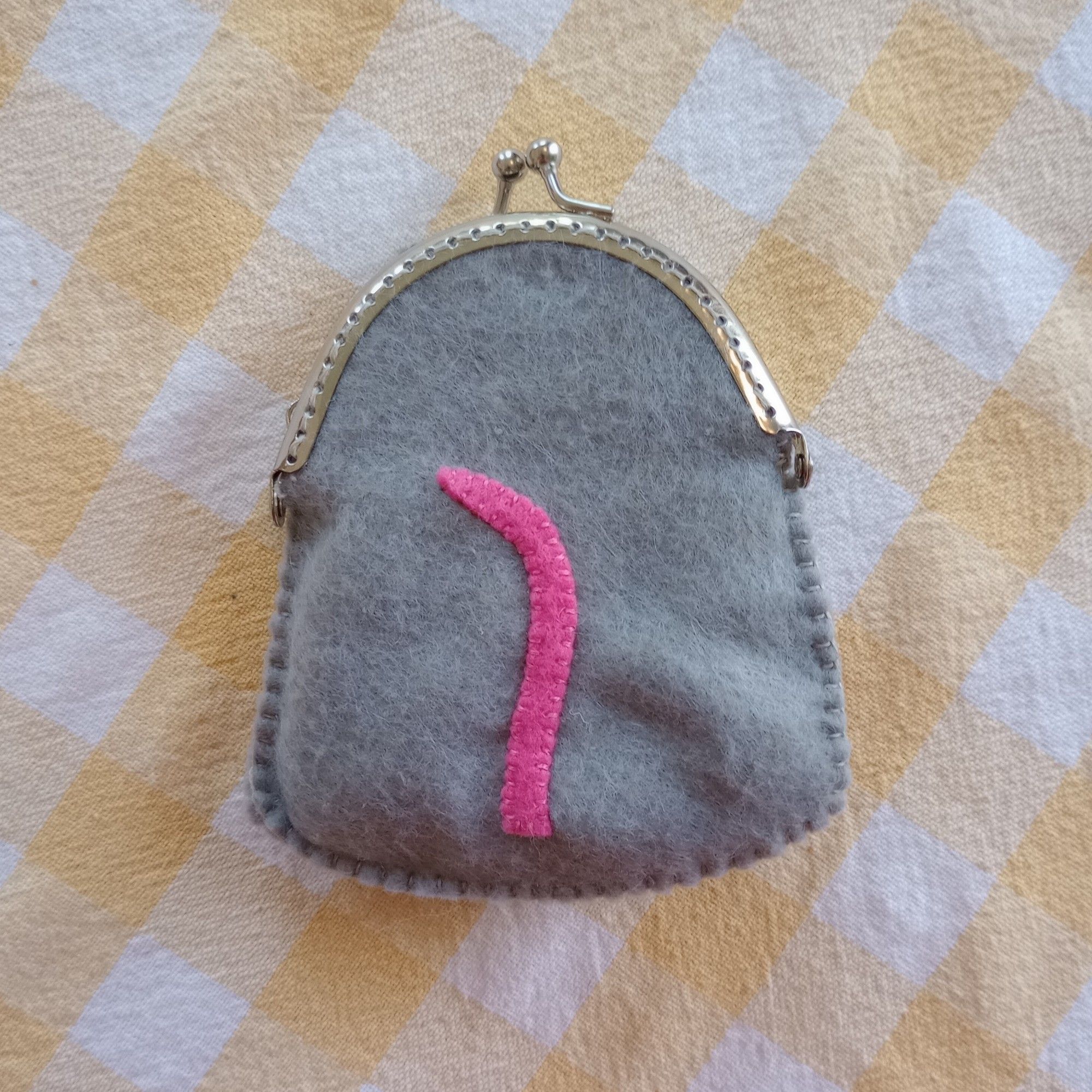 Here's a photo of the back of the bag. We see a pink little tail with a bit of a curl.