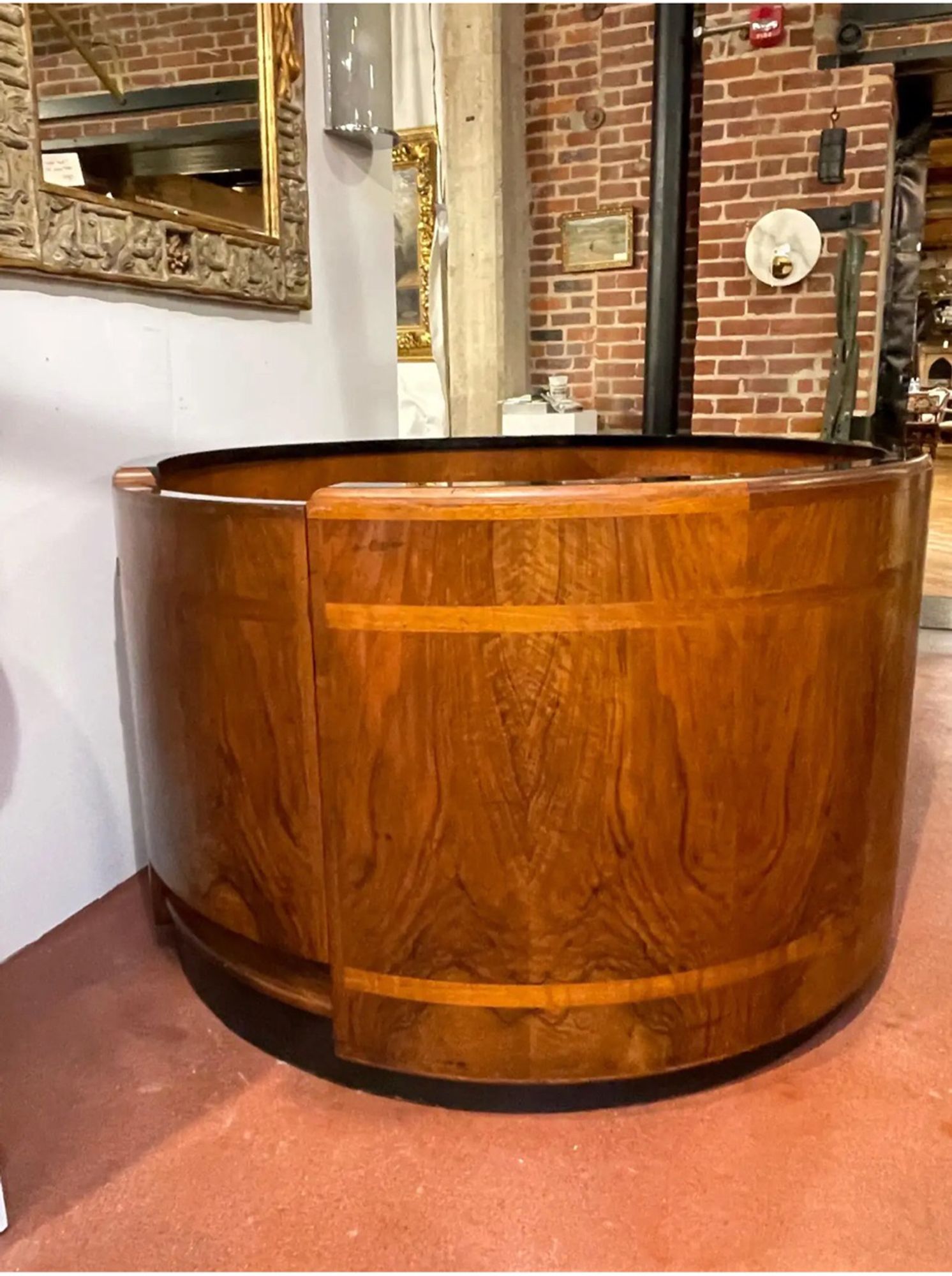 Circular Reception Desk
USA, Circa 1930s
Attributed to Donald Deskey for Rockefeller Center
A masterwork example of American Art Deco/ Machine Age period furniture.
This unique sculptural circular desk, the top fitted with the original inset black glass, resting on the round conforming case, subtly crafted of stunning book-matched burled mahogany with satinwood inlaid upper and lower bands.
Complete with a concealed swing entrance door, revealing a generous walk -in work space. The front is fitted with a level writing desk with an ingenious concealed mechanical fold in lower work desk, offering numerous optional uses, its perfect for a computer. The lower part of the desk is flanked to left is a pull out shelf, with four drawers. The right side is fitted with a pull out shelf, with three drawers. Raised on a ebonized pedestal base.
* The Rockefeller Center provenance is by repute, at the time of posting & not officially confirmed, research ongoing 
$35,000 on chairish.com