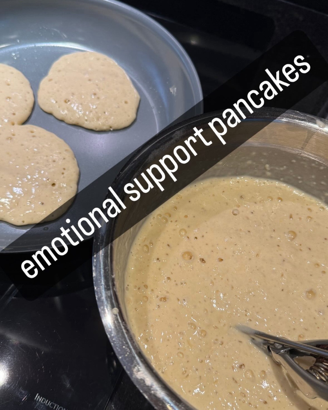 Photo of a bowl of batter next to pancakes cooking, with the caption "emotional support pancakes"