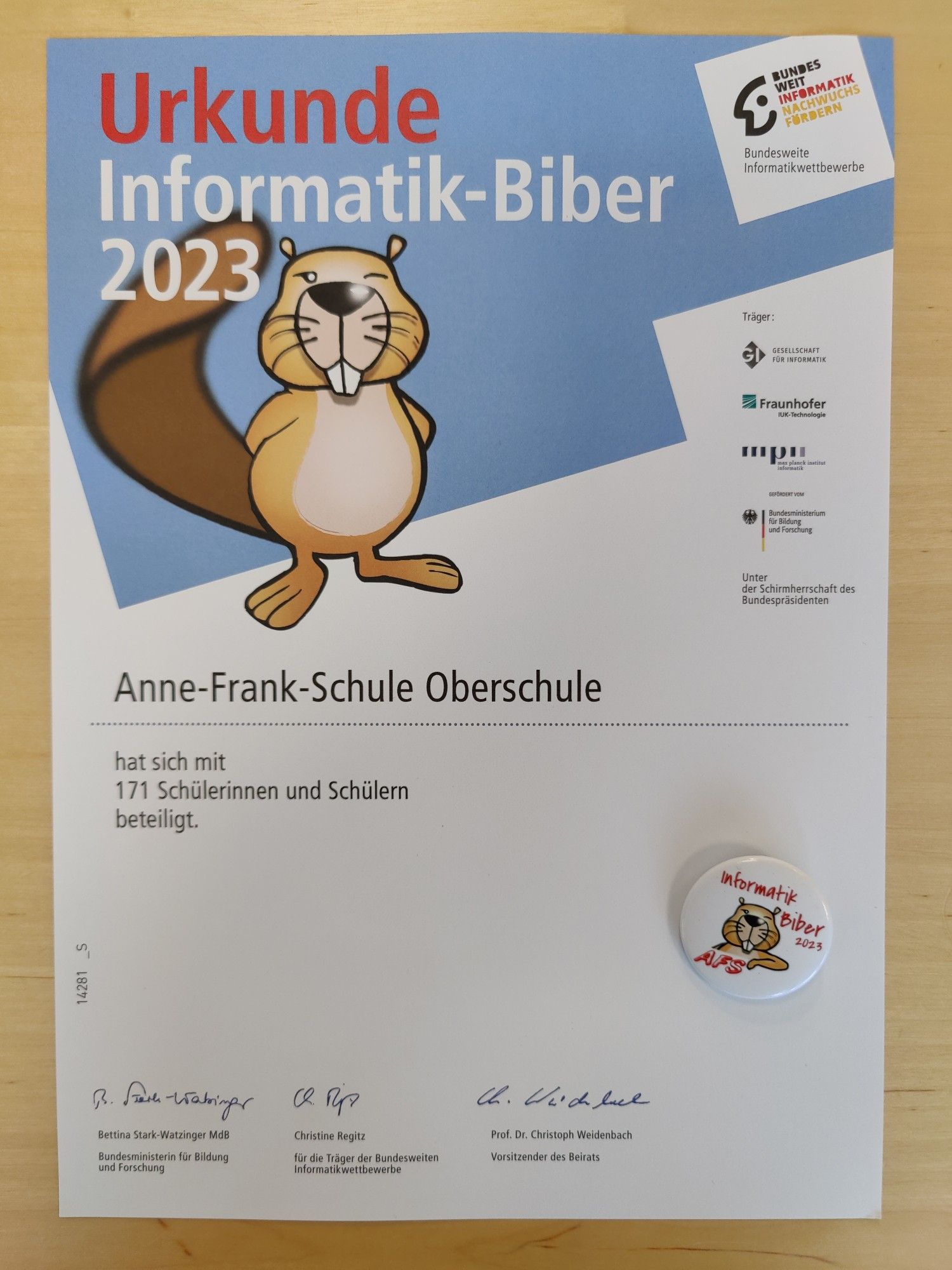 Urkunde über die Teilnahme von 171 Schülerinnen und Schülern am Wettbewerb für die Anne-Frank-Schule und ein Button mit dem Biber-Logo und dem Aufdruck "Informatik-Biber 2023 AFS"