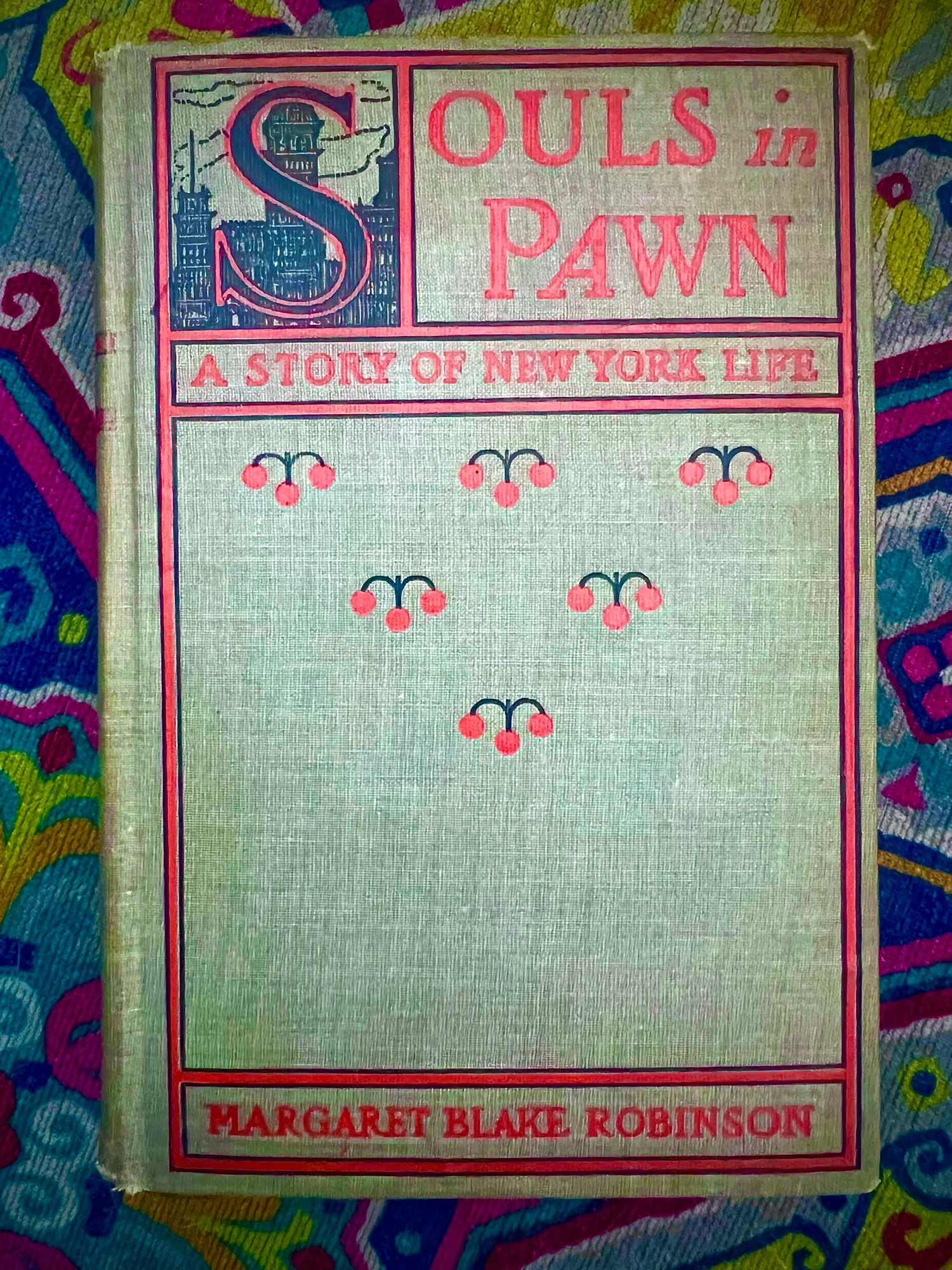 A copy of the book Souls in Pawn (1901) by Margaret Blake Robinson. It is decorated with several cartoon street lamps and a photo of the skyline in the top left corner. Under the title, it reads “A story of New York life.”