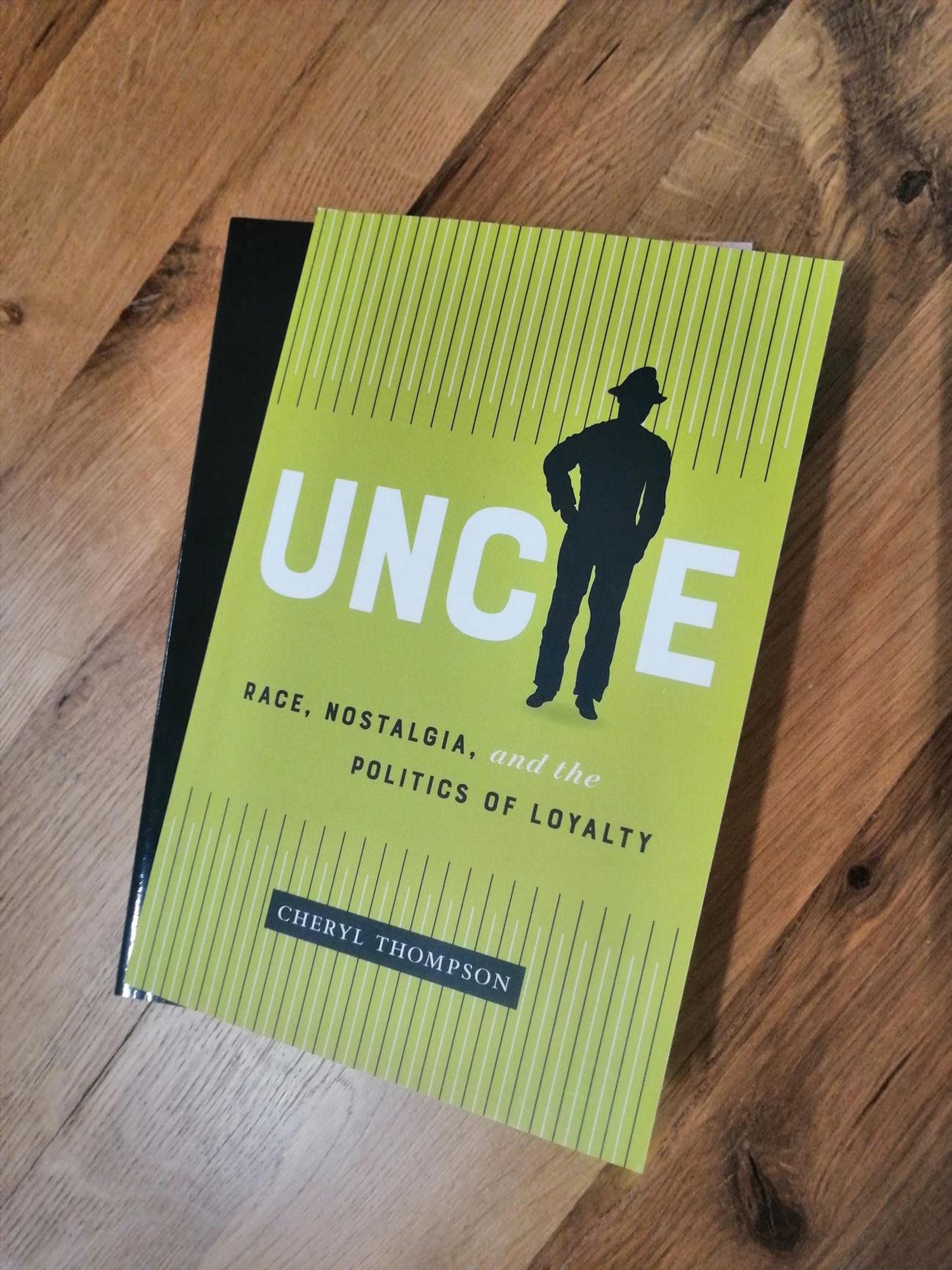 The book Uncle by Cheryl Thompson on a wooden table