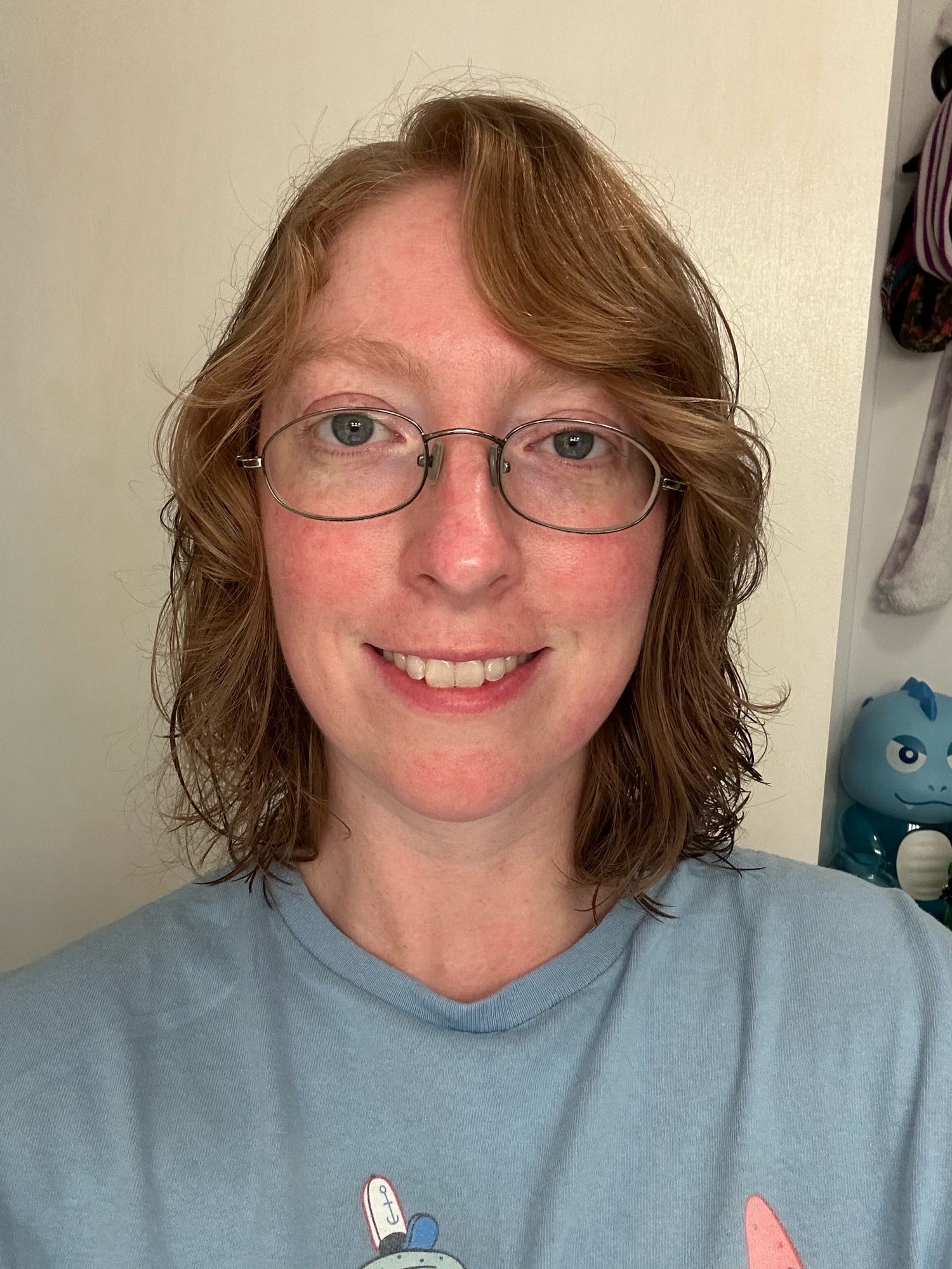 A real photo of a human woman with hair just above the shoulders and glasses, from the shoulders up.