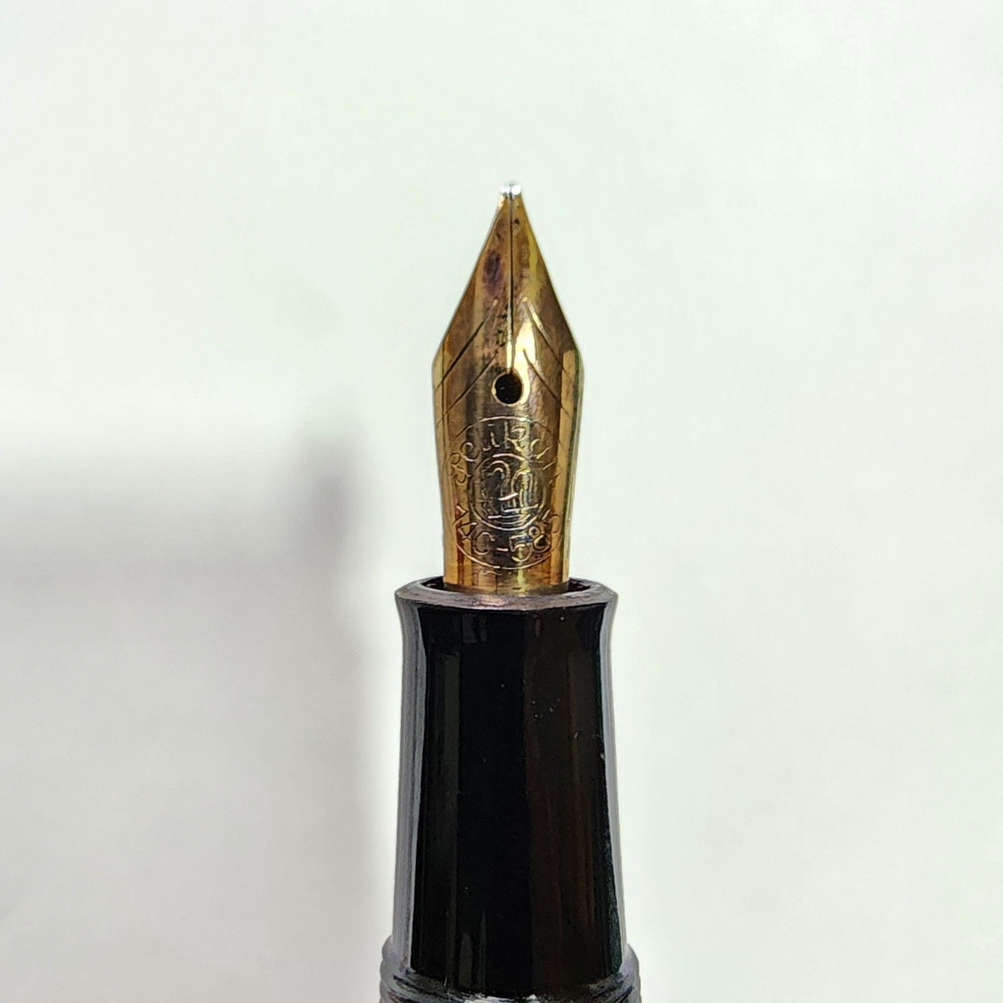 Close up of the nib of a Pelikan 140 fountain pen. The nib is golden