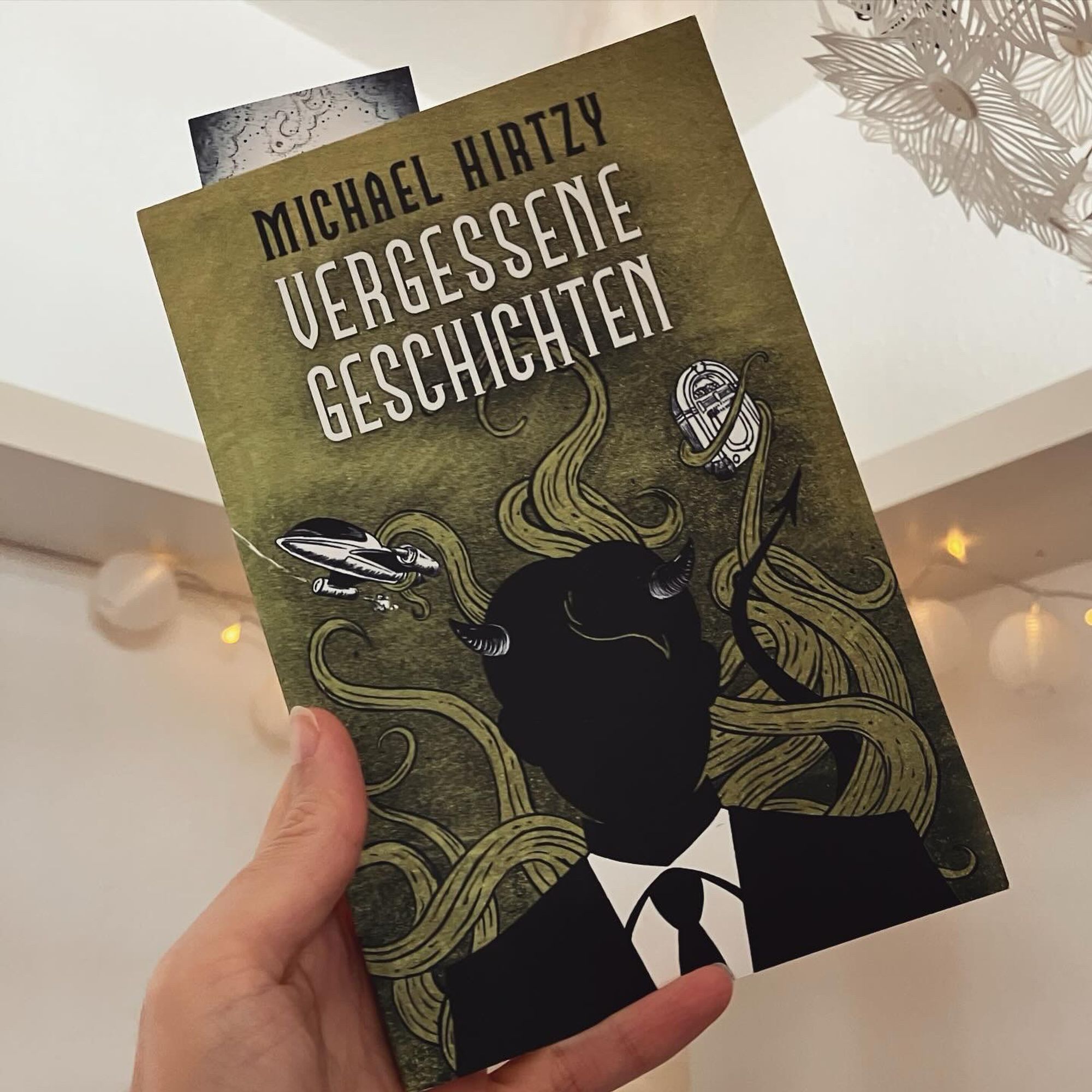 Eine Hand hält das Buch "Vergessene Geschichten" von Michael Hirtzy in die Höhe.