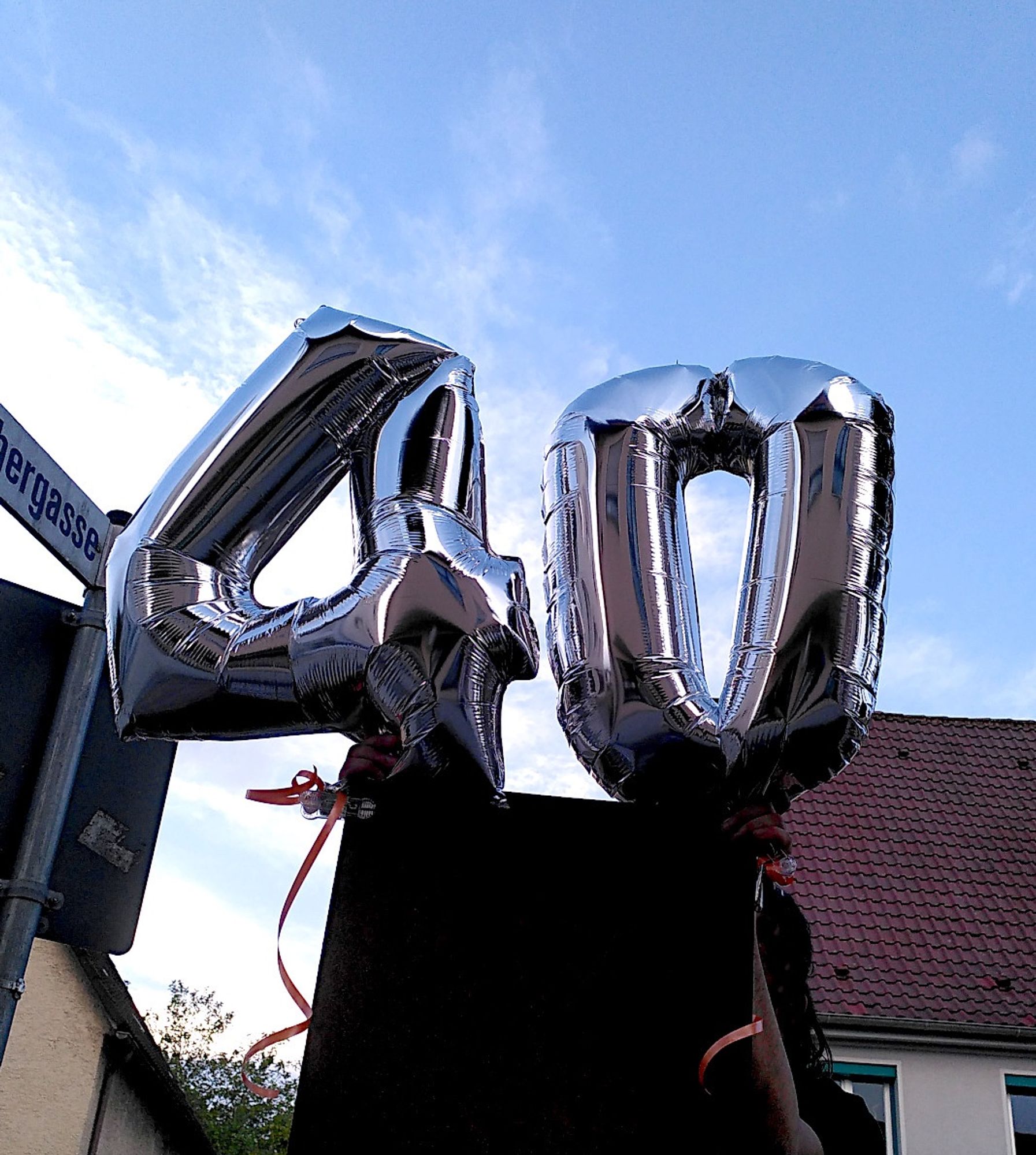 Zwei silberne Luftballons, die die Zahlen 4 und 0 darstellen.