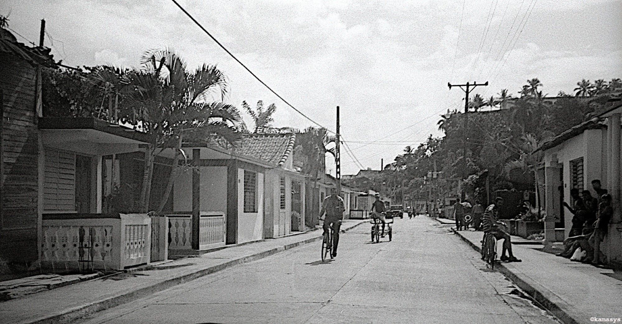 Ciclistas en una calle de Baracoa, la ciudad más vieja de Cuba, al noreste de la isla. Foto en blanco y negro.