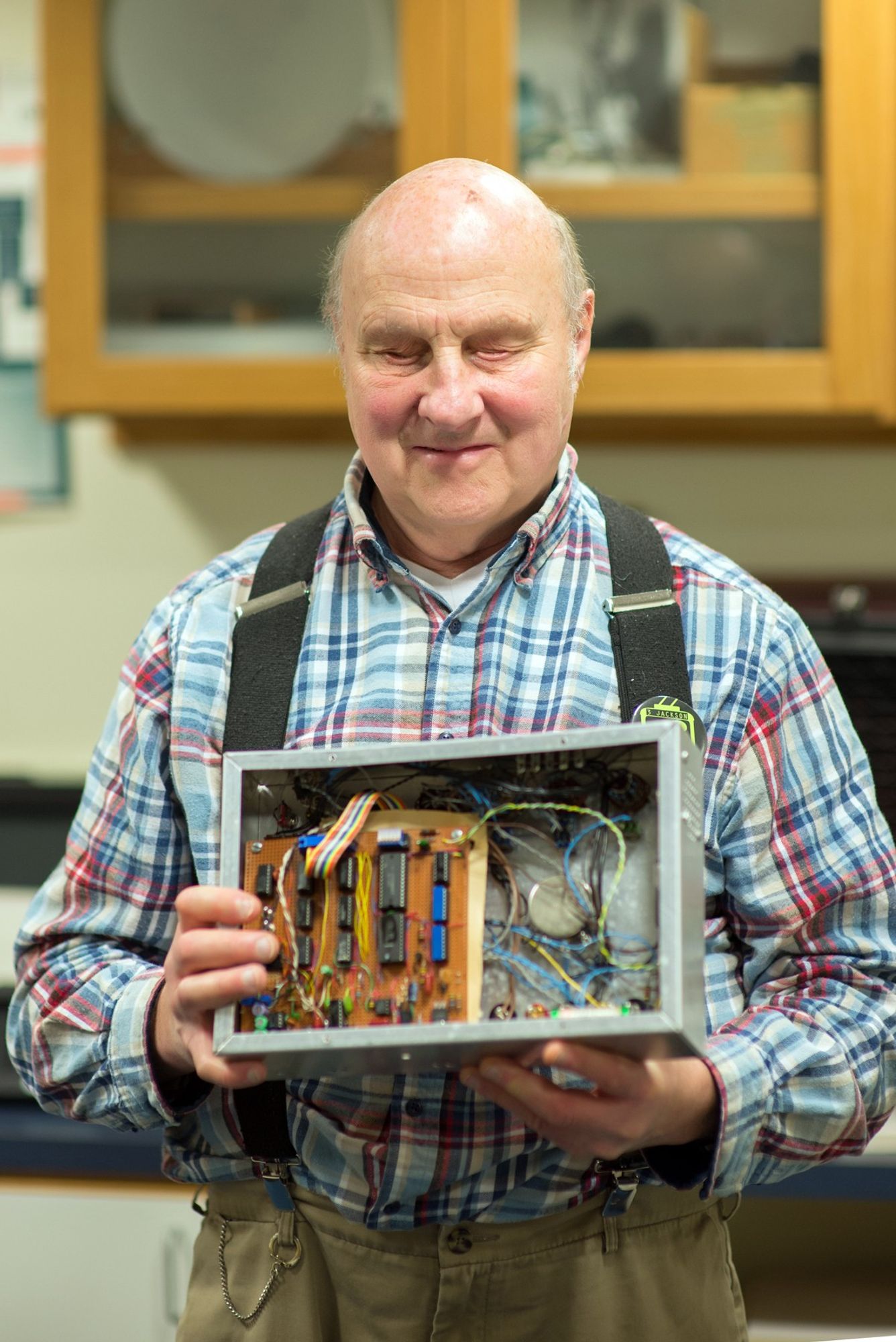 photograph of Bill Gerrey holding one of his electronic inventions