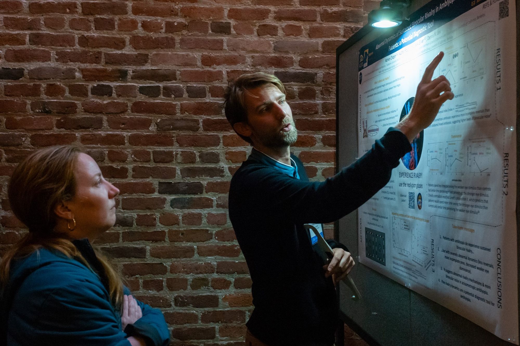 Adrien Chopin presenting a scientific poster to a colleague