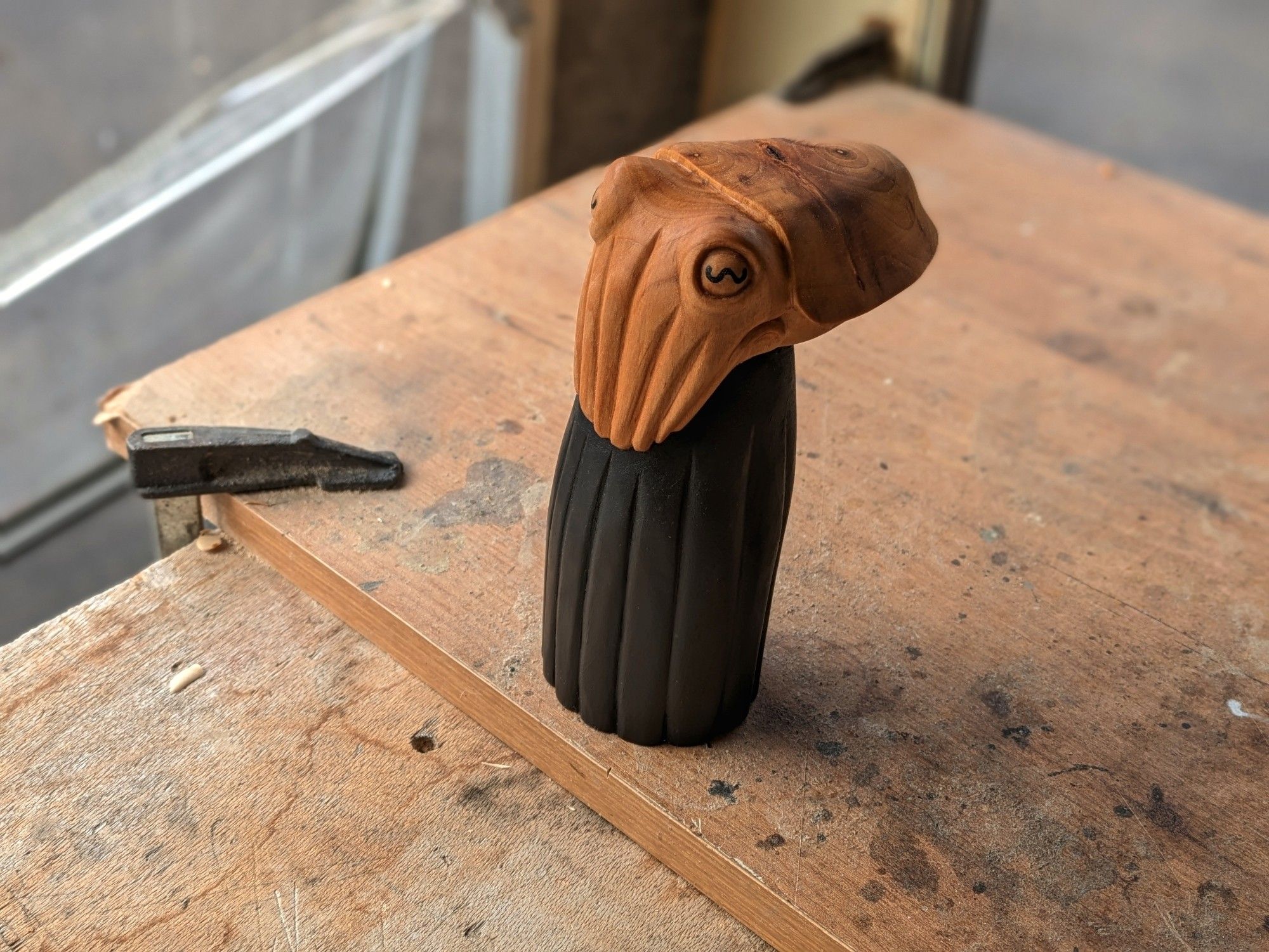 A woodcarved cuttlefish wearing a black dress