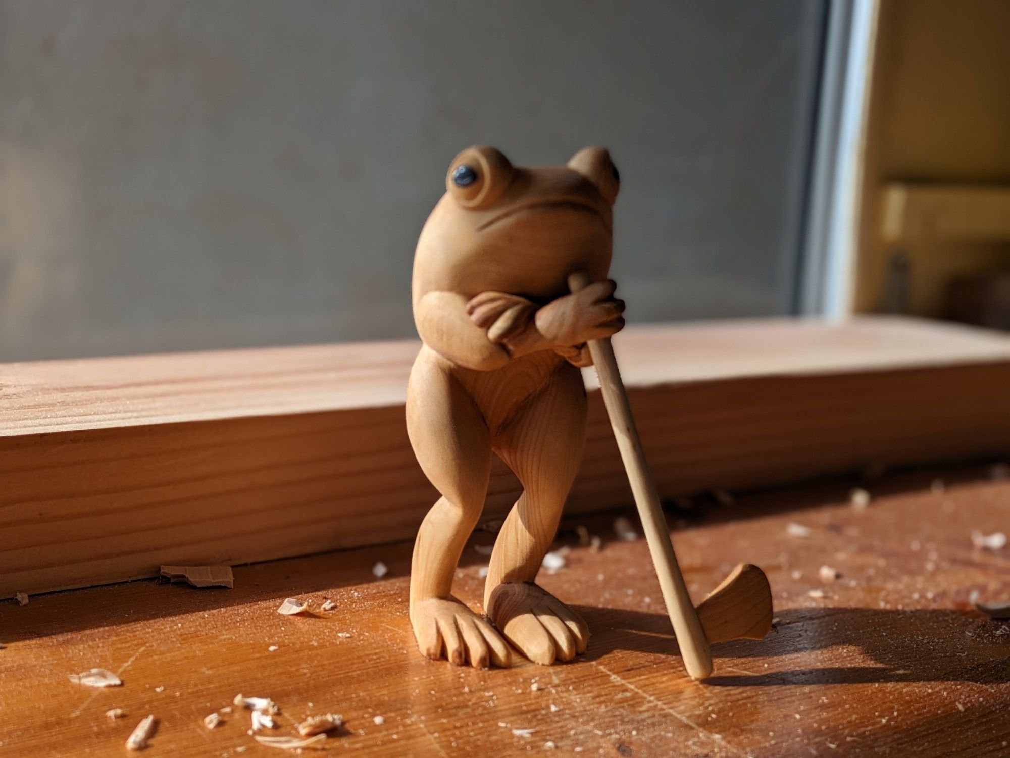 A standing frog with an ax