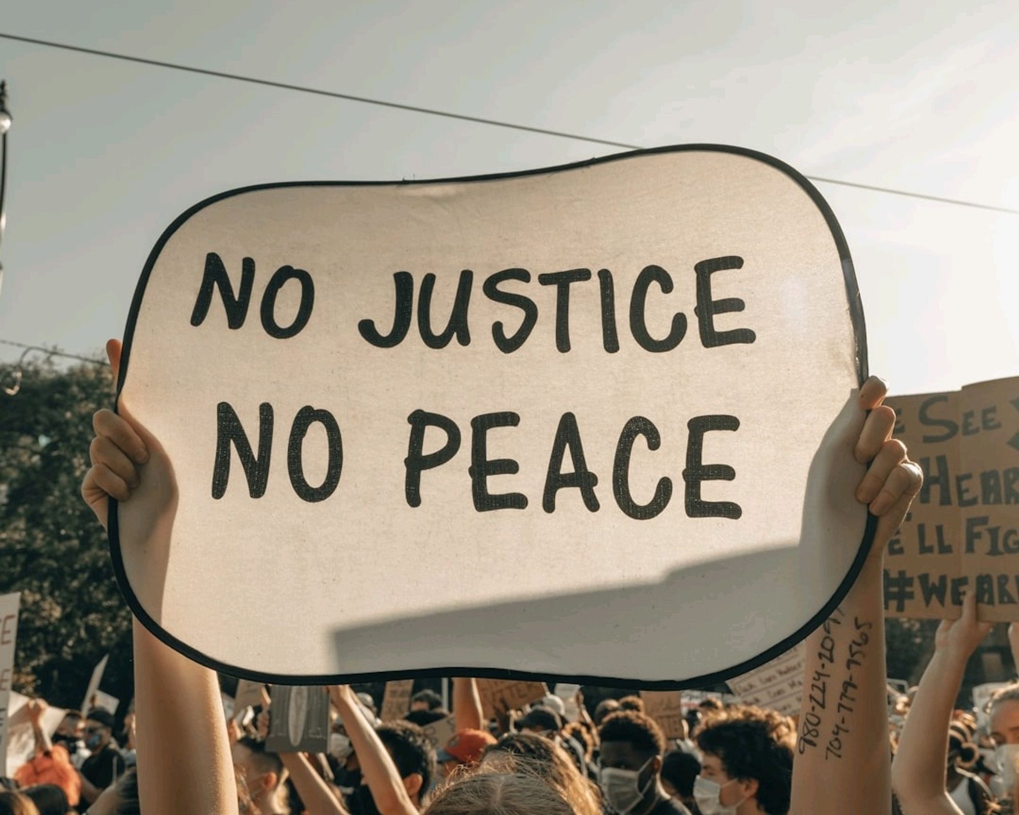 Slogan "no justice, no peace" sur une pancarte 