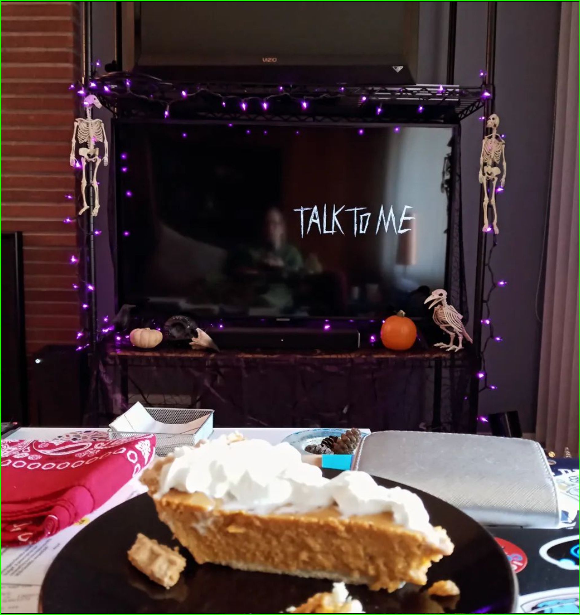 the title screen for Talk To Me on my TV and a slice of pumpkin pie on a plate in the foreground.