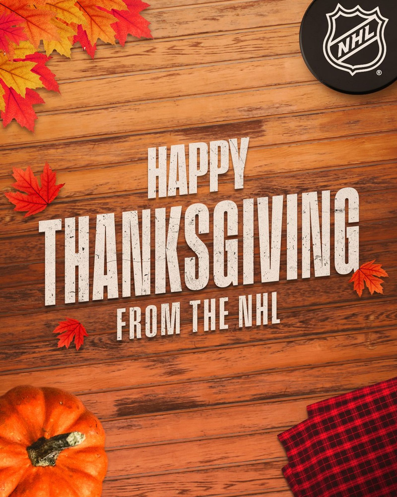 White text on a wooden background that has leaves, a puck, and flannel towel reading, "Happy Thanksgiving from the NHL".