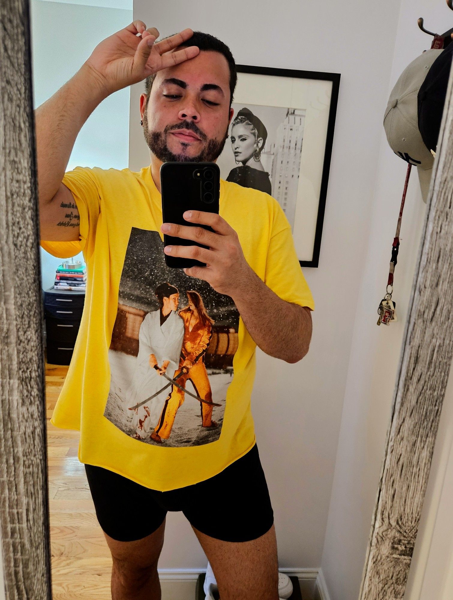 A mirror selfie of a mid-30's Puerto Rican male in a yellow Kill Bill t-shirt and boxers briefs.