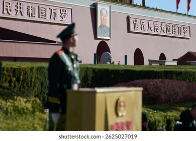 Mao portrait on a building, soldier is looking at it