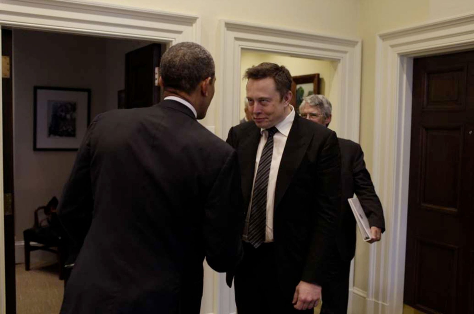 Musk shaking Obama's hand. Same creepy smile.