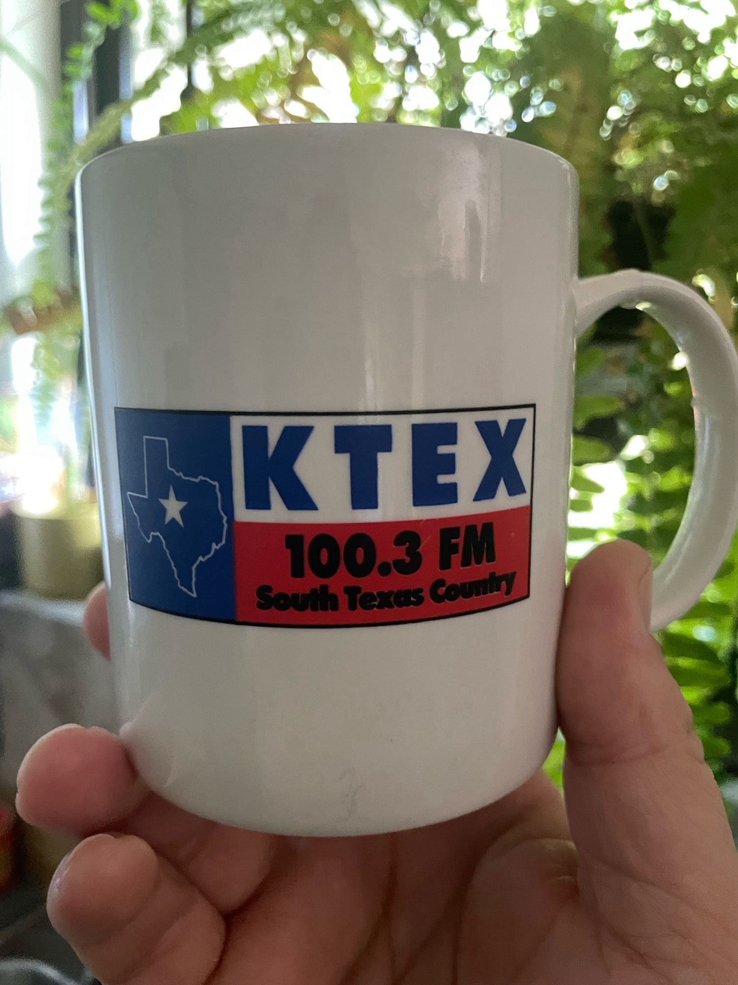 The other side of the mug shows the logo for KTEX 103.3 FM -South Texas Country. The text is inside the Texas flag, and the blue section of the flag that normally has the star is replaced with an outline of Texas which itself has a star in it.