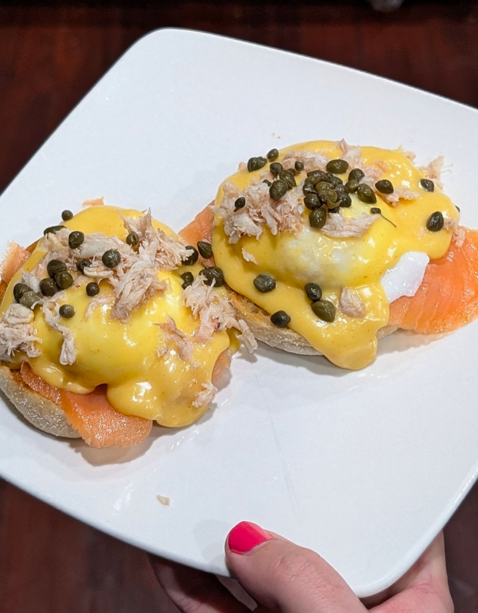 Salmon eggs Benedict with crab claw meat and capers