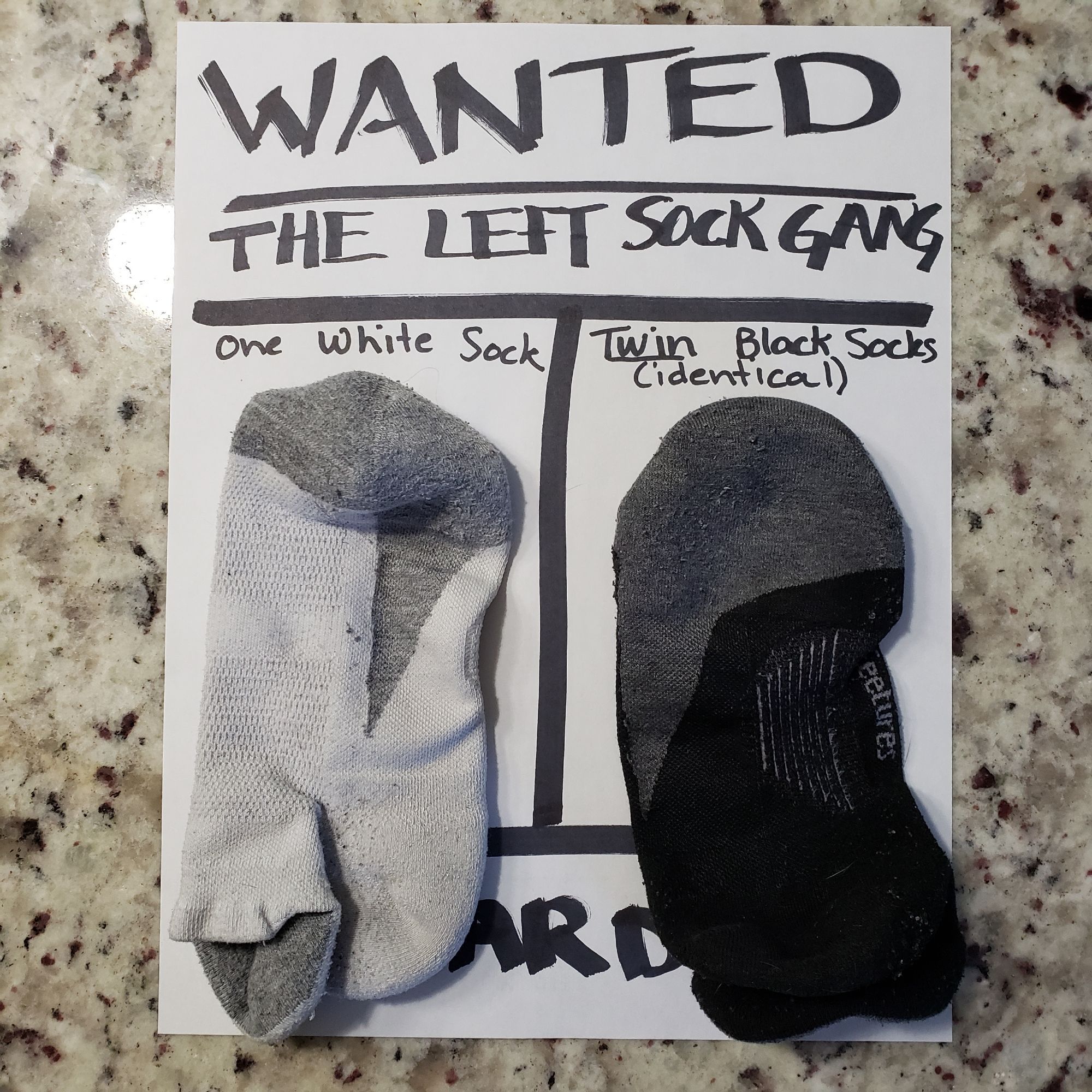 Wanted poster with two right socks laying on it.