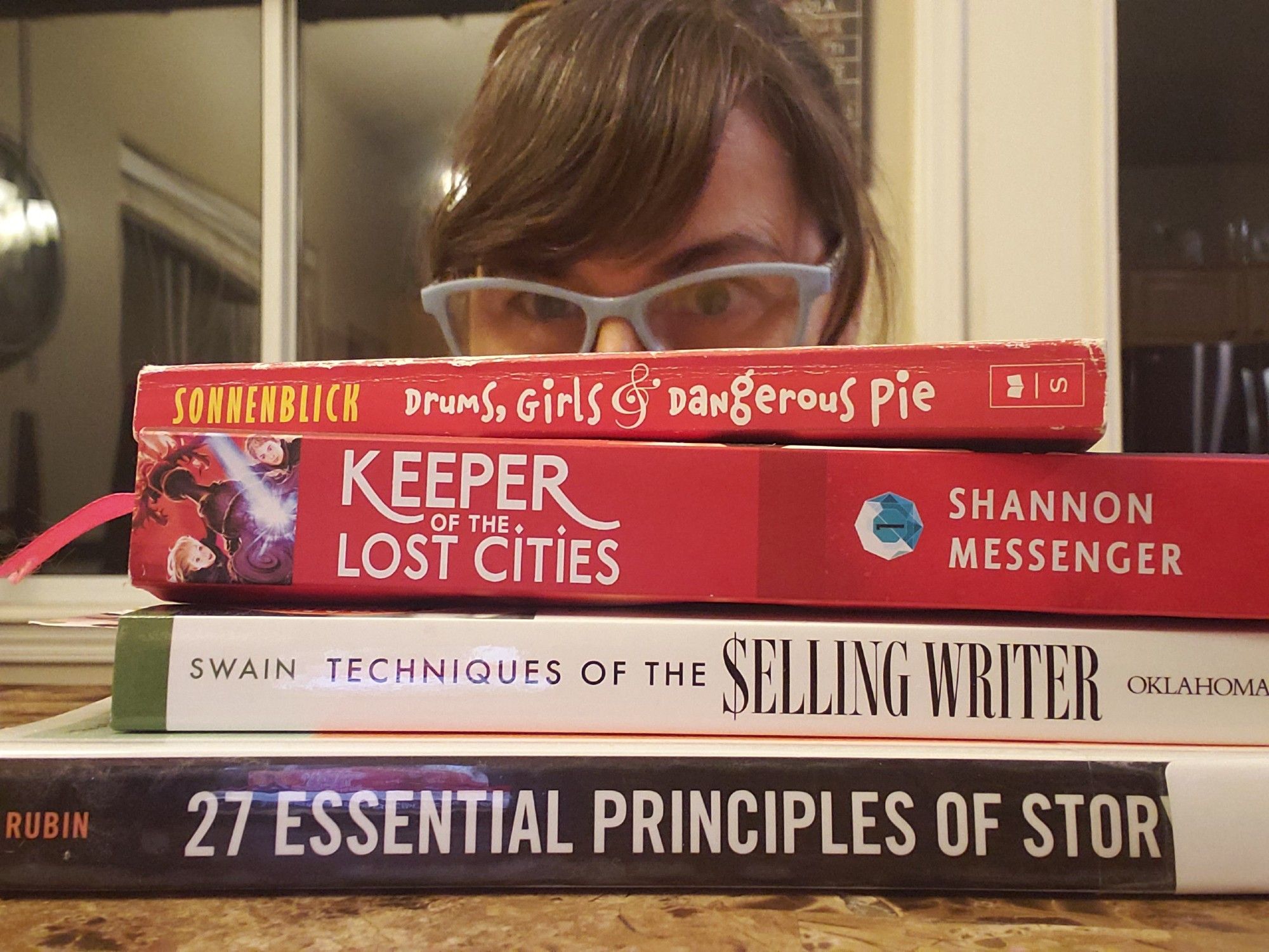 Me behind a stack of books:
Drums, Girls, and Dangerous Pie
Keeper of the Lost Cities
27 Essential Principles of Story
Techniques of a Selling Writer