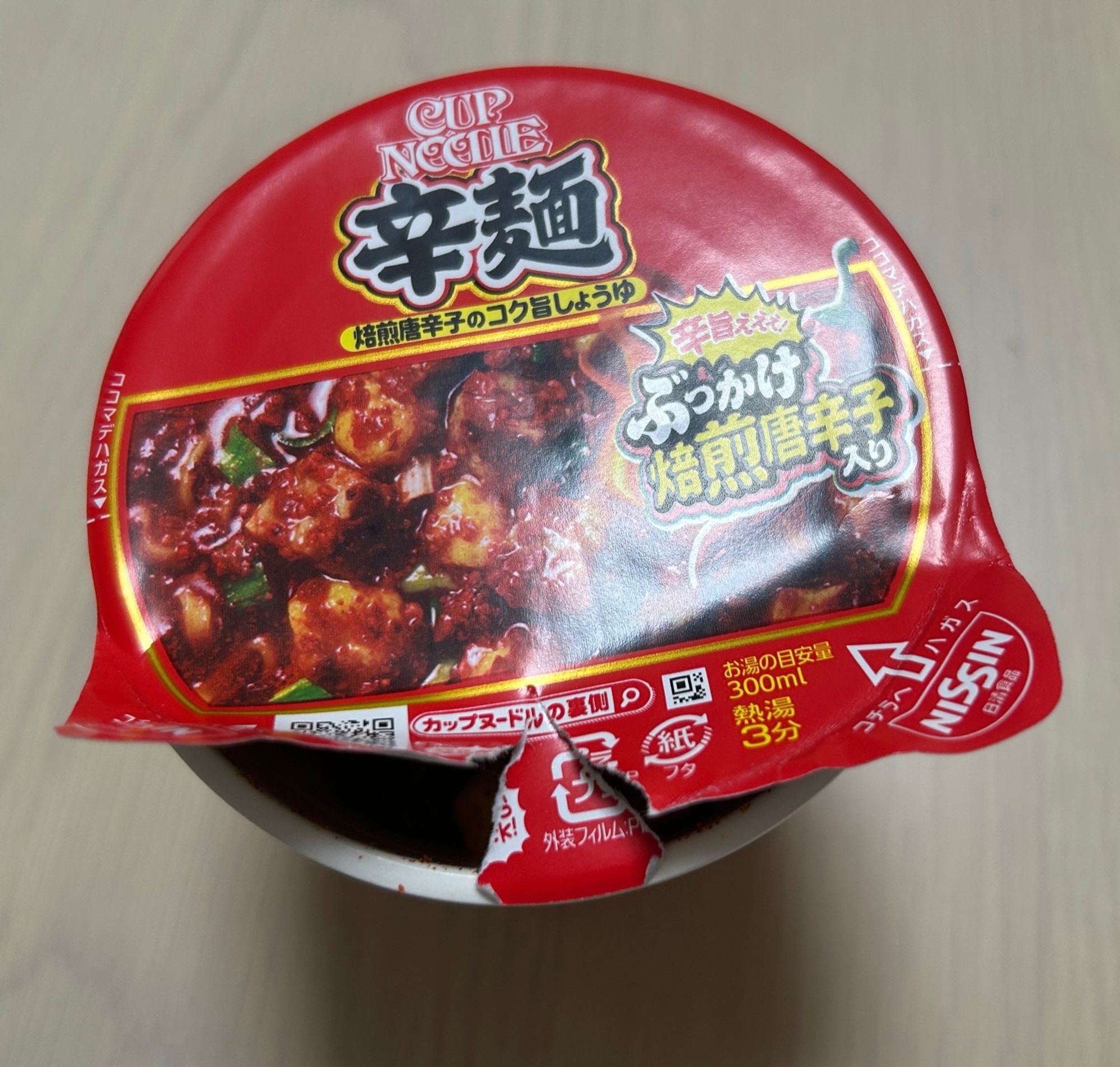 両端だけ破けて中央が残っているカップ麺の蓋