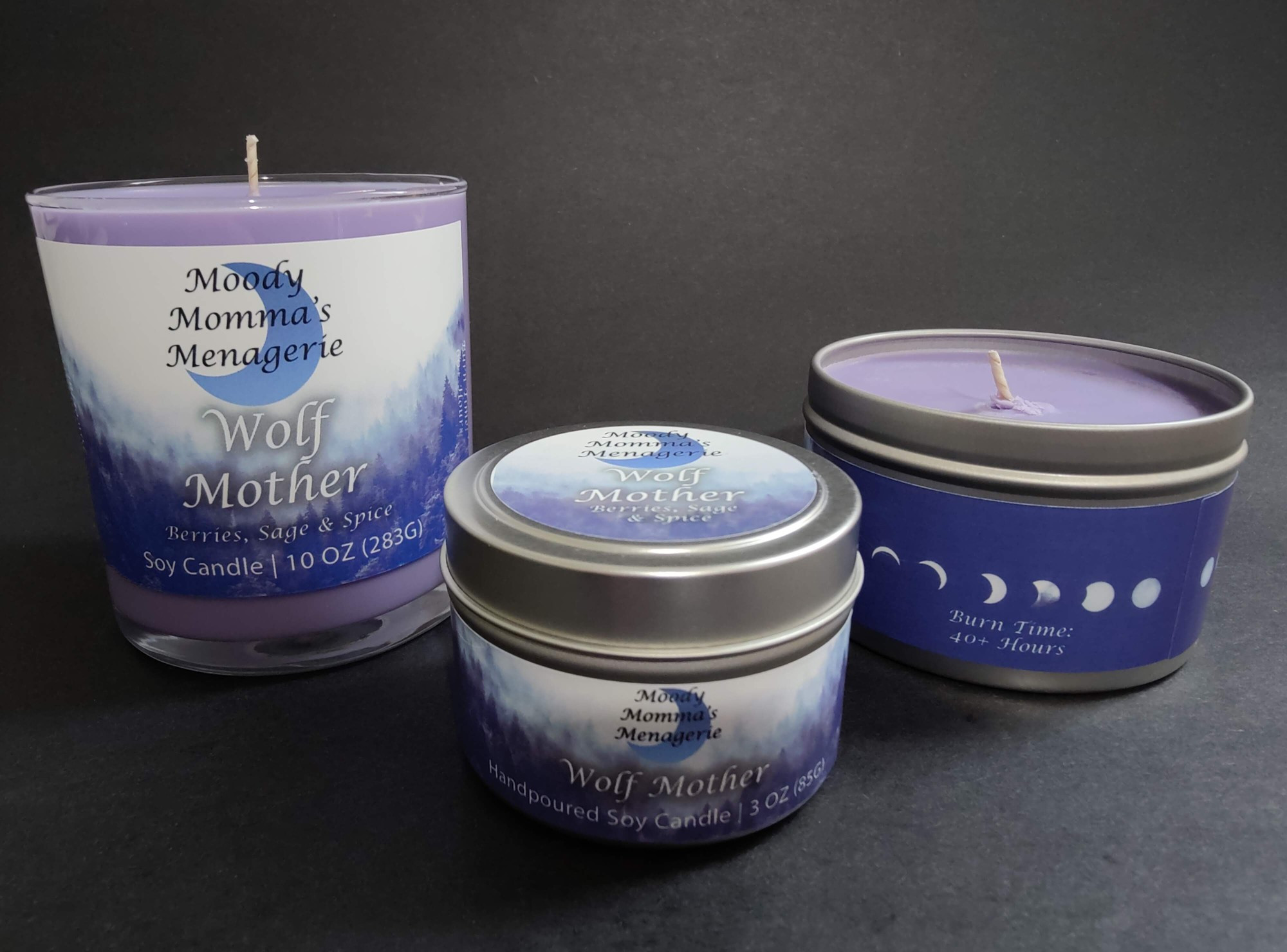 Three sizes of purple soy candles with my branding in the scent Wolf Mother, a Berries, Sage & Spice fragrance