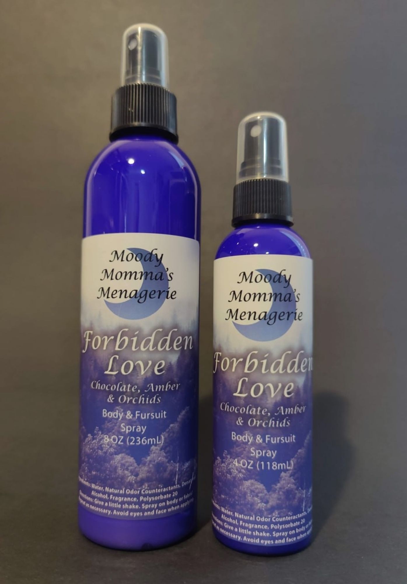 An 8 ounce blue bottle and a 4 ounce blue bottle of body/fabric spray in the fragrance Forbidden Love. The fragrance notes are Chocolate, Amber & Orchids