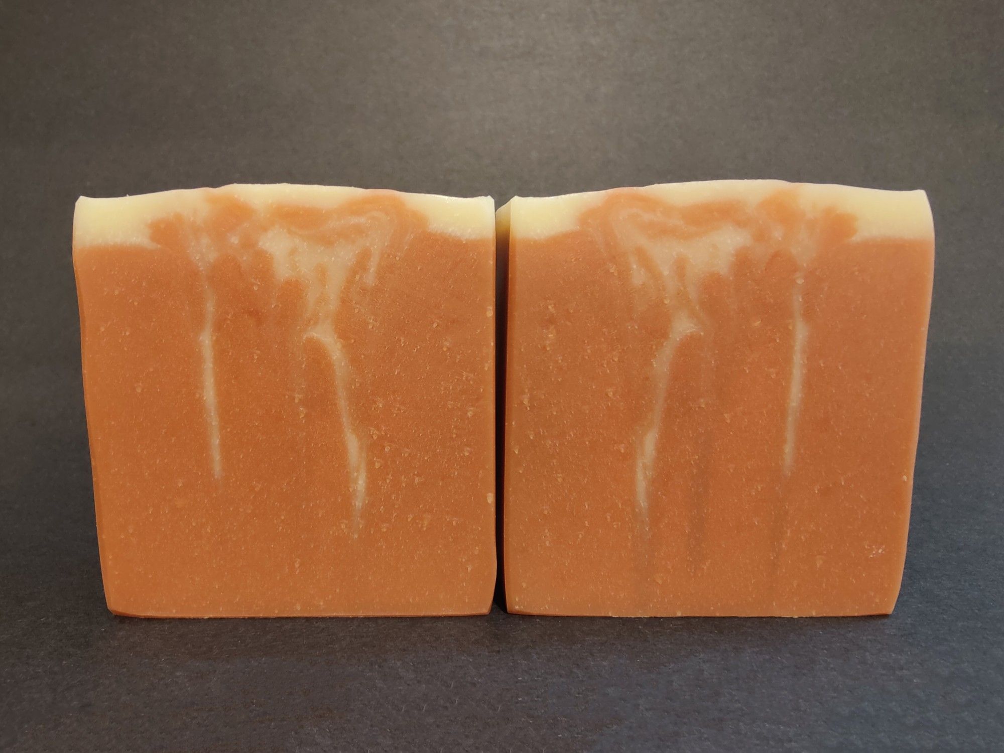 Two bars of bronze colored soaps with streaks of cream through the middle, reminiscent of solar flares