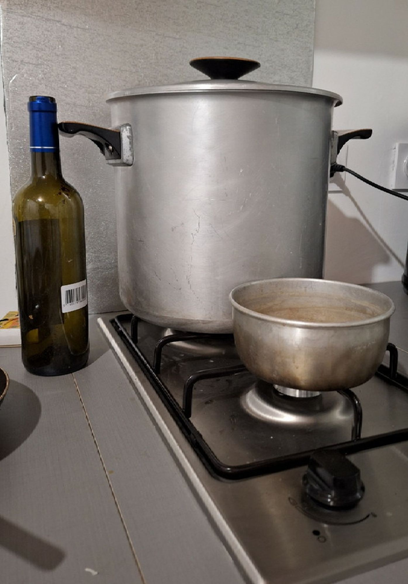 Vast pan on titchy two-ring gas hob, taller than a wine bottle and wide as a bucket. 