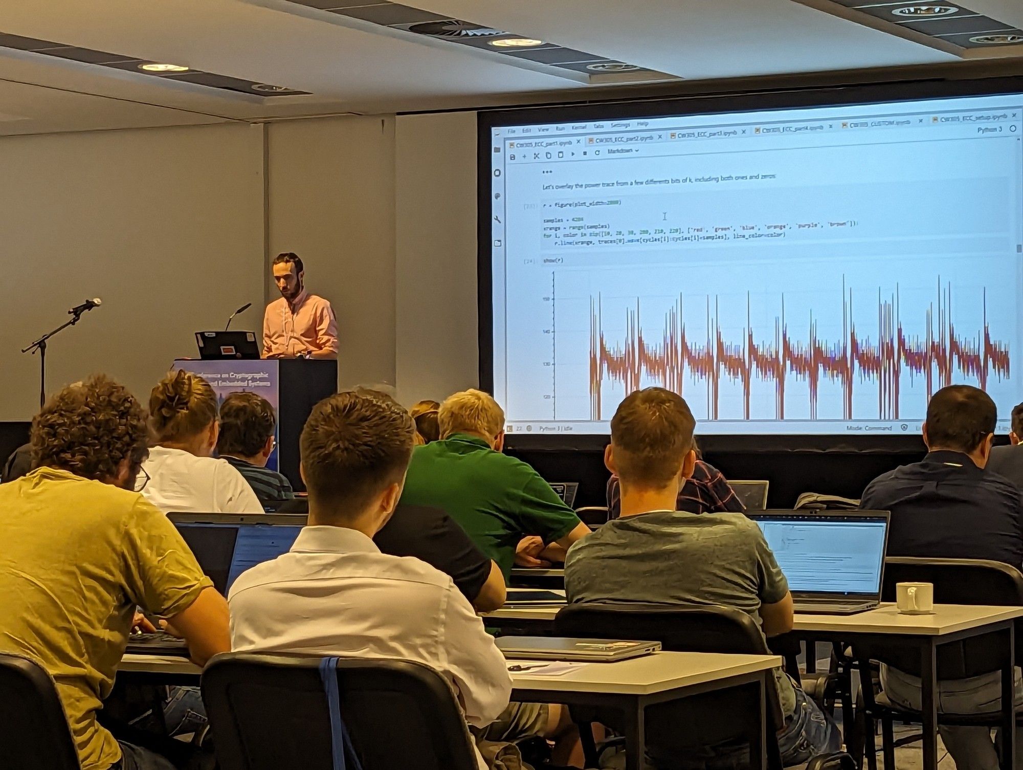 J-P from newae in front of a presentation screen, with power waveforms visible