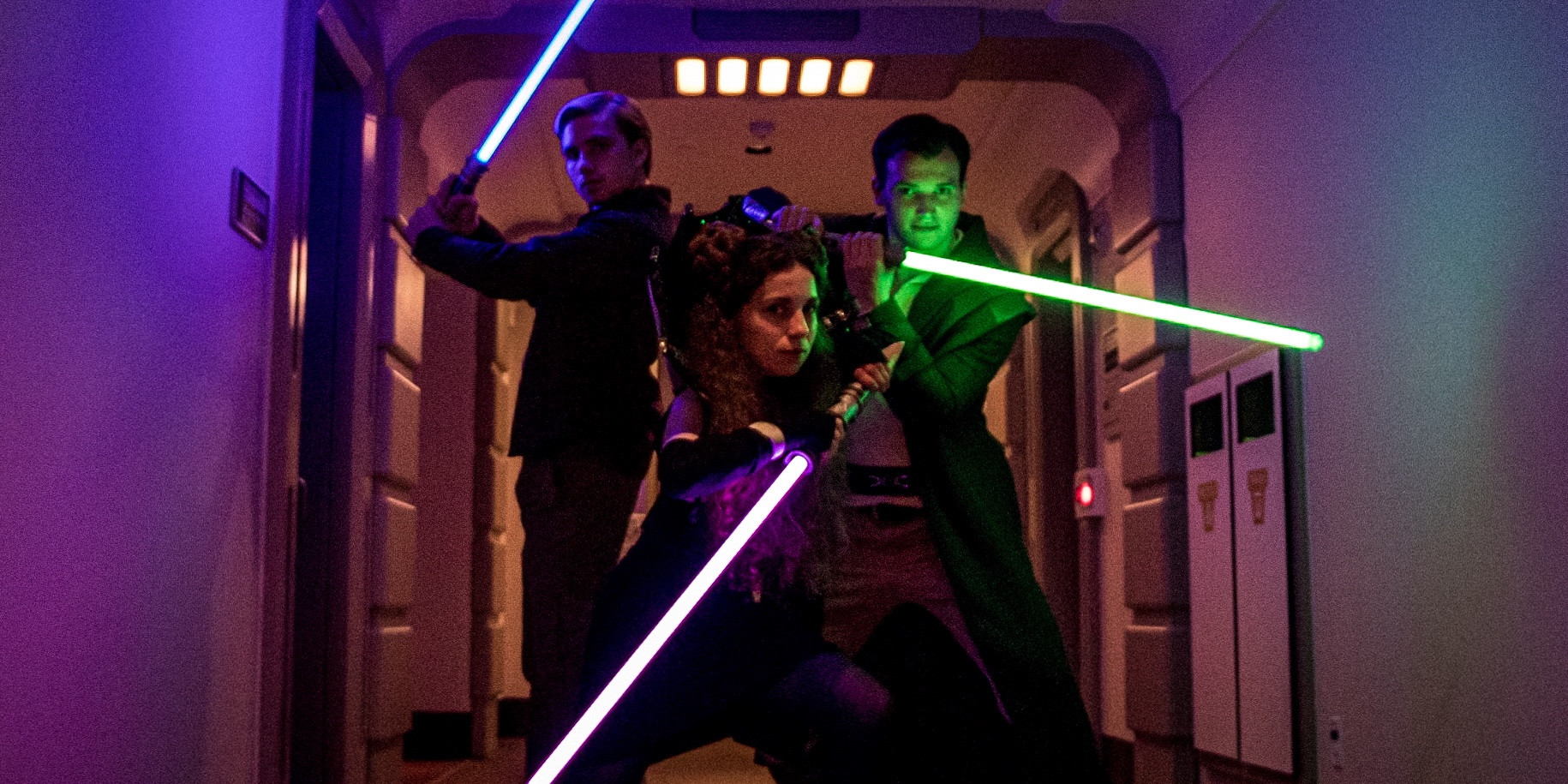 A photo of Colton and two of his friends aboard the Galactic Starcruiser Halcyon. All three of them are wielding lightsabers and the overall impression is of a young adult book cover