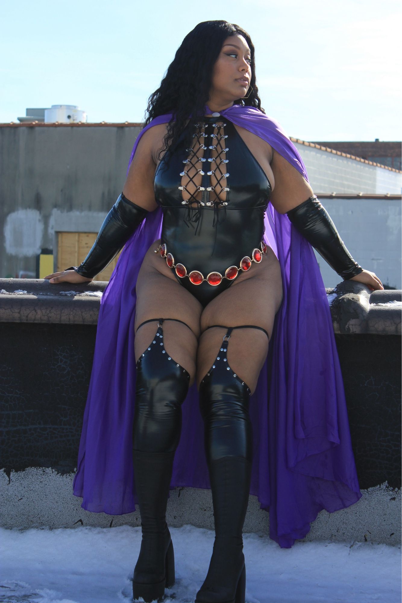 Me dressed as Raven from Teen titans sitting on the ledge of a roof top. Snow at my feet. My purple cape falling behind me